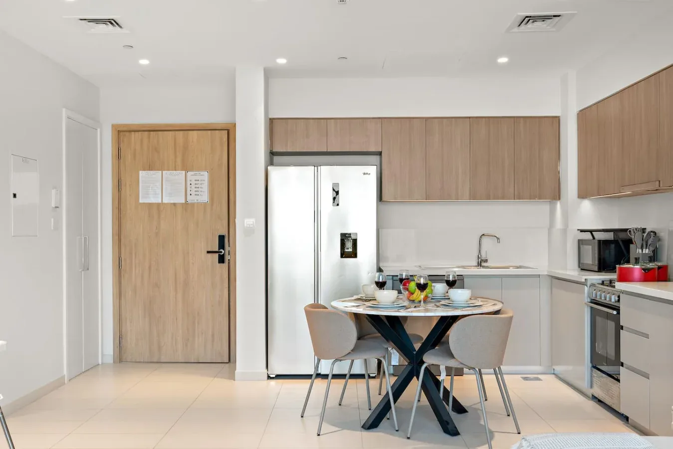 A bright kitchen and dining area with a table set beside the cabinets.