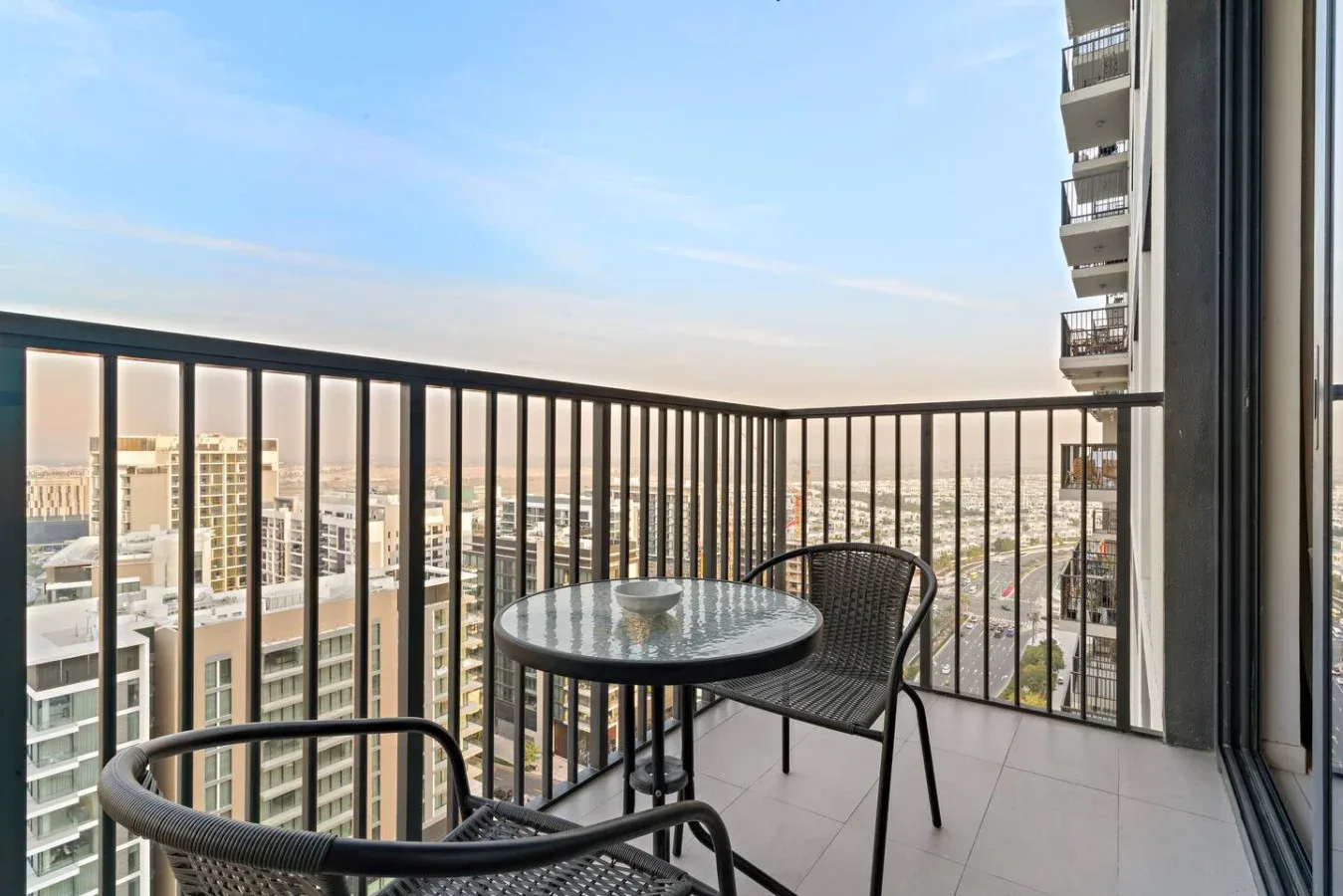 A balcony seating area with a round table and city views.