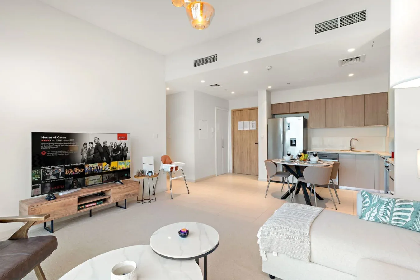 A bright open-plan living room with a dining area and kitchen.