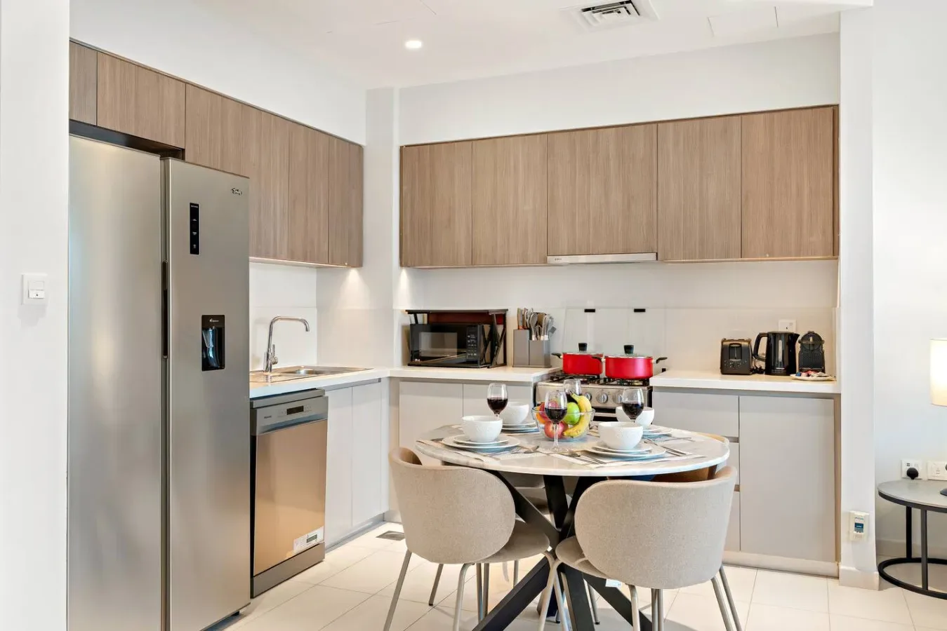 Una cocina moderna con gabinetes de madera y una mesa de comedor en el centro.