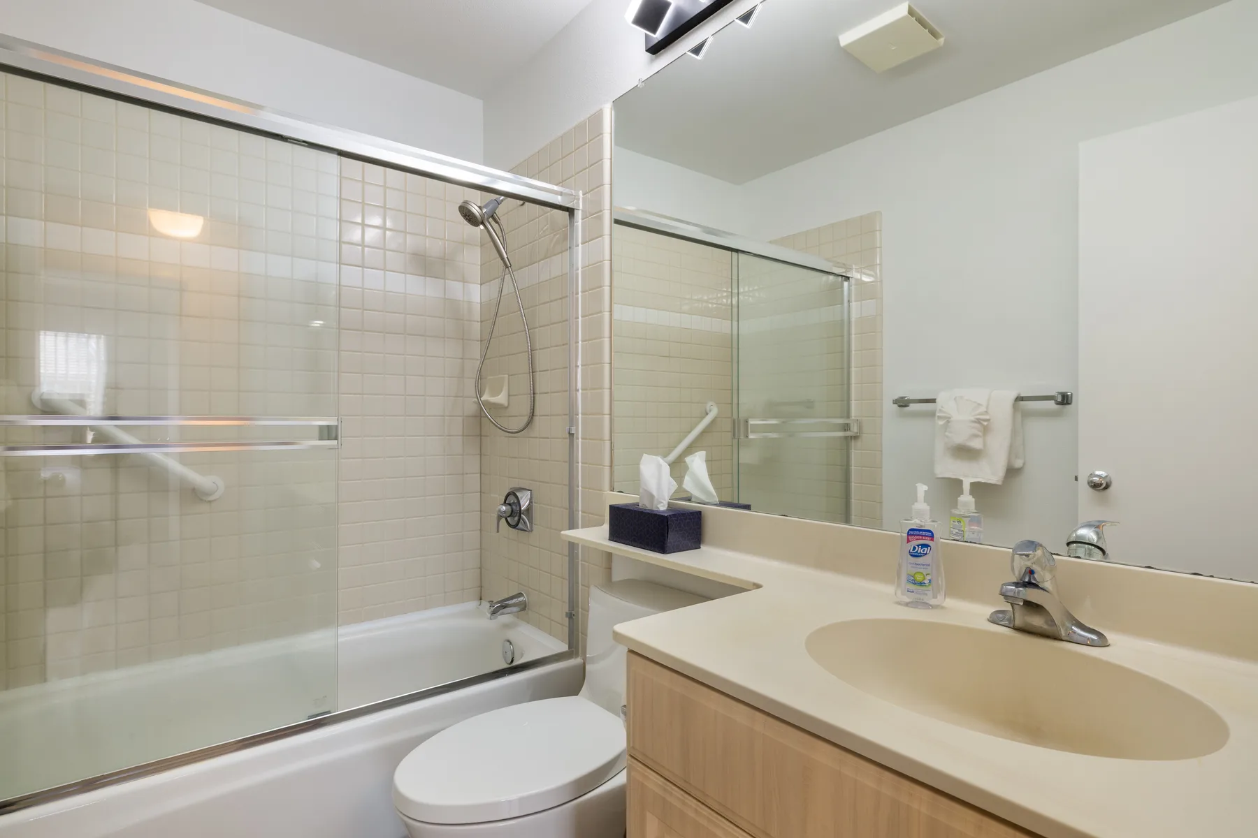 A bathroom with a glass-enclosed shower and a sink vanity.