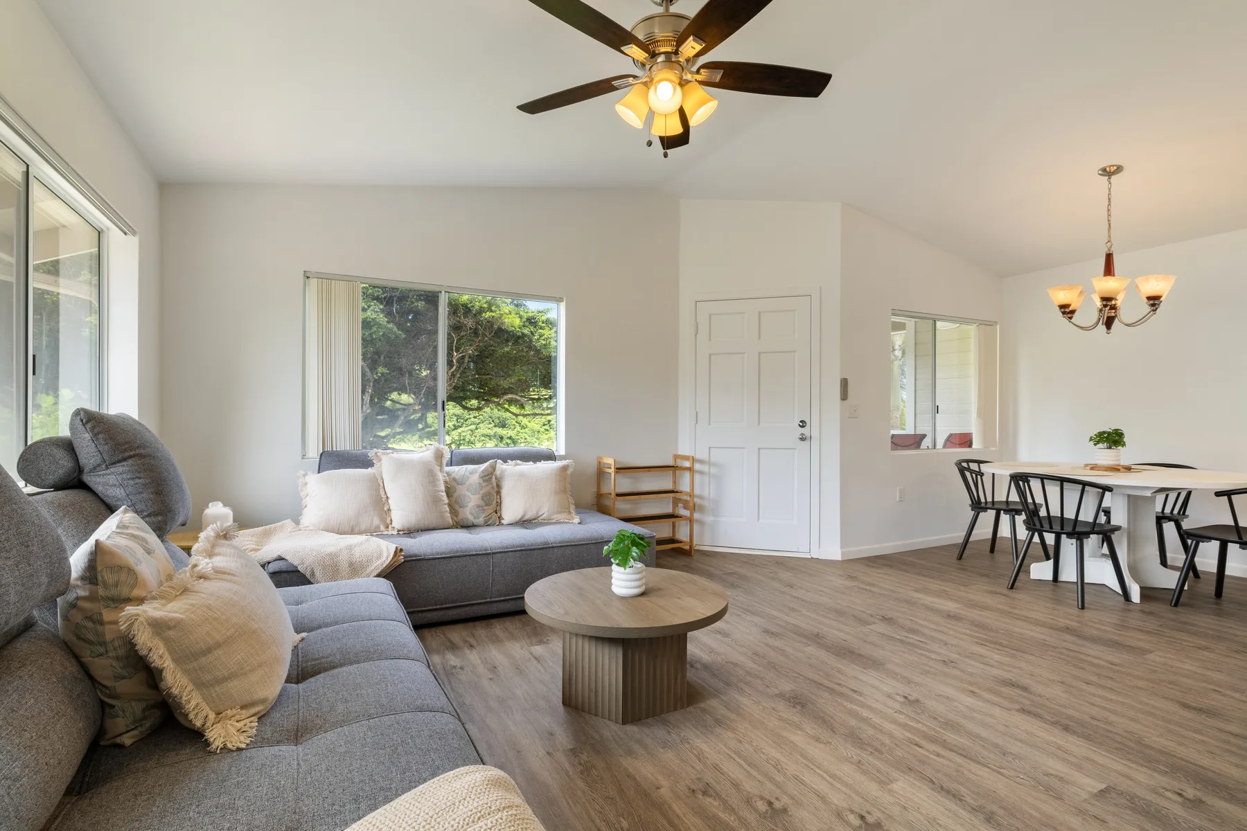 A bright living and dining area with seating, a coffee table, and a dining table.