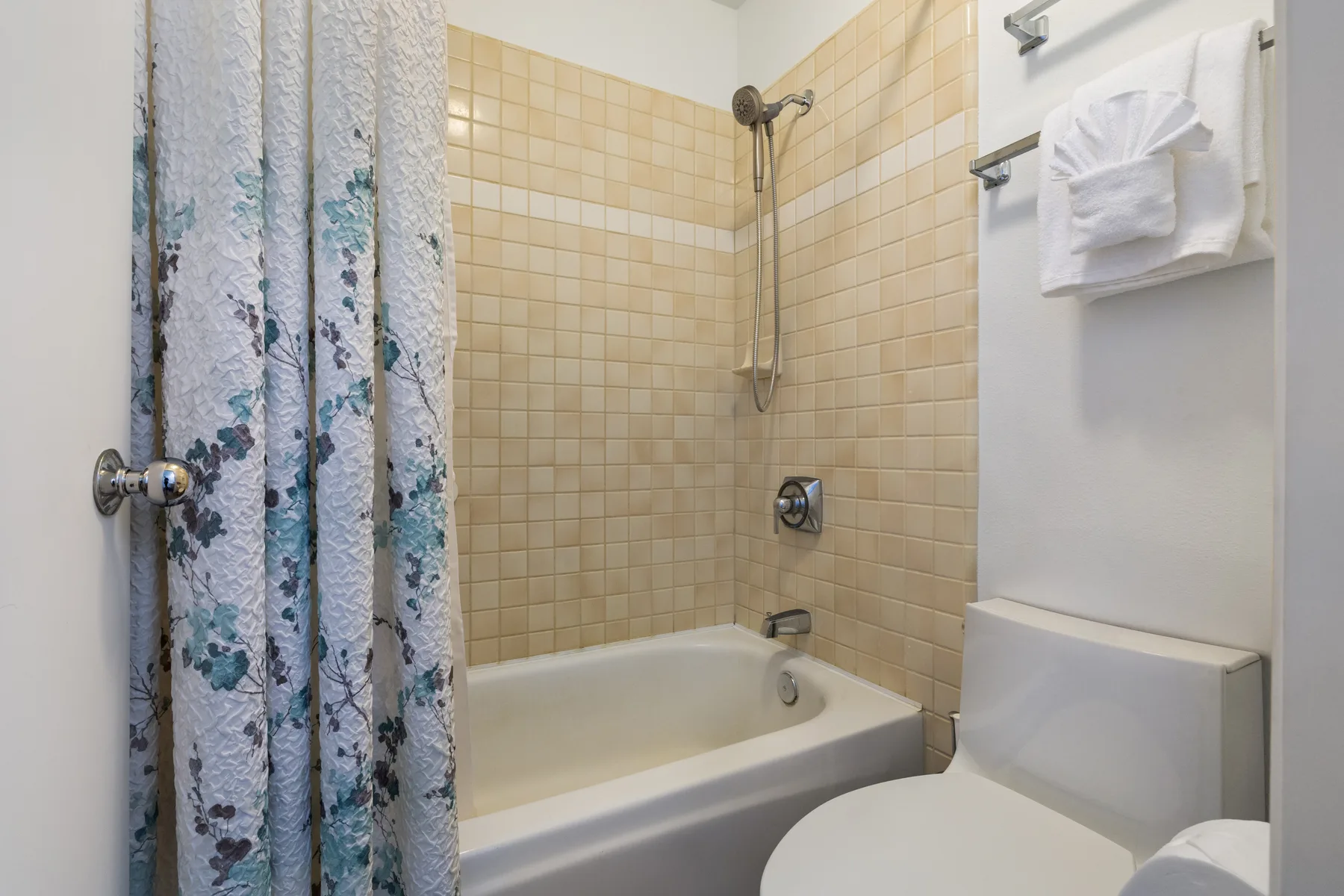 A bathroom with a bathtub, shower, and toilet.