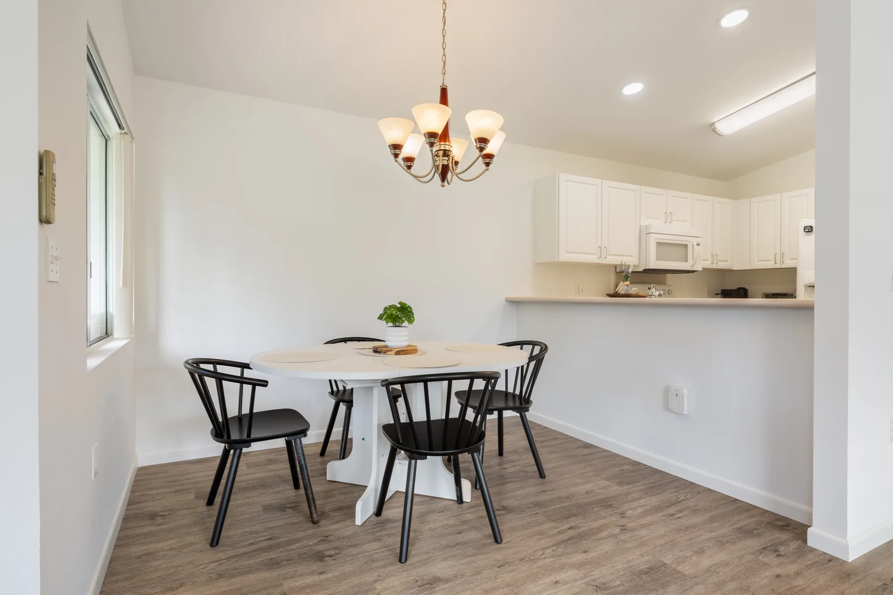 A dining area with a table and chairs beside an open kitchen.