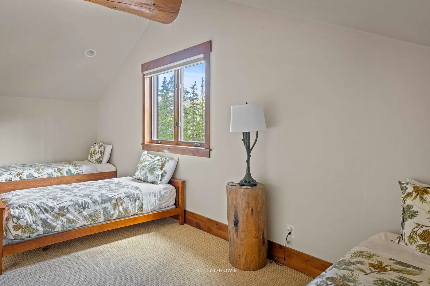 Un dormitorio con ropa de cama floral, una ventana y una lámpara de pie.