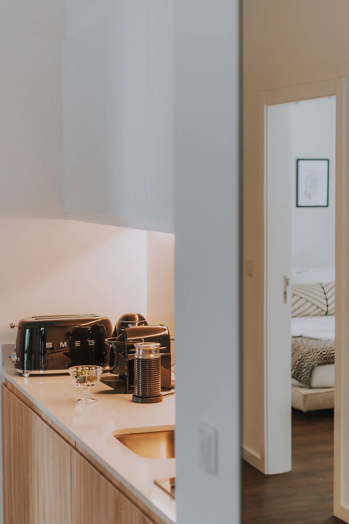 Una encimera de cocina con una tostadora y utensilios para preparar café junto a una puerta.