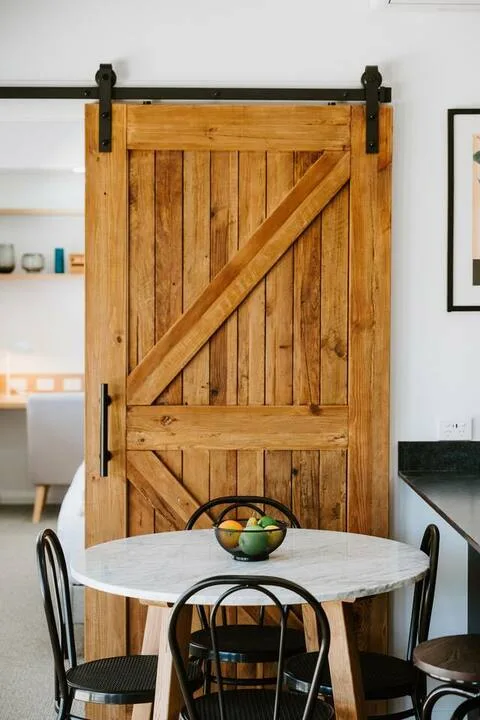 Comedor con una mesa redonda y una puerta corrediza de madera.