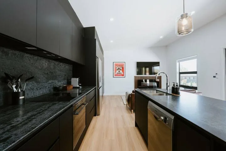 Una cocina moderna con encimeras oscuras y una isla central.