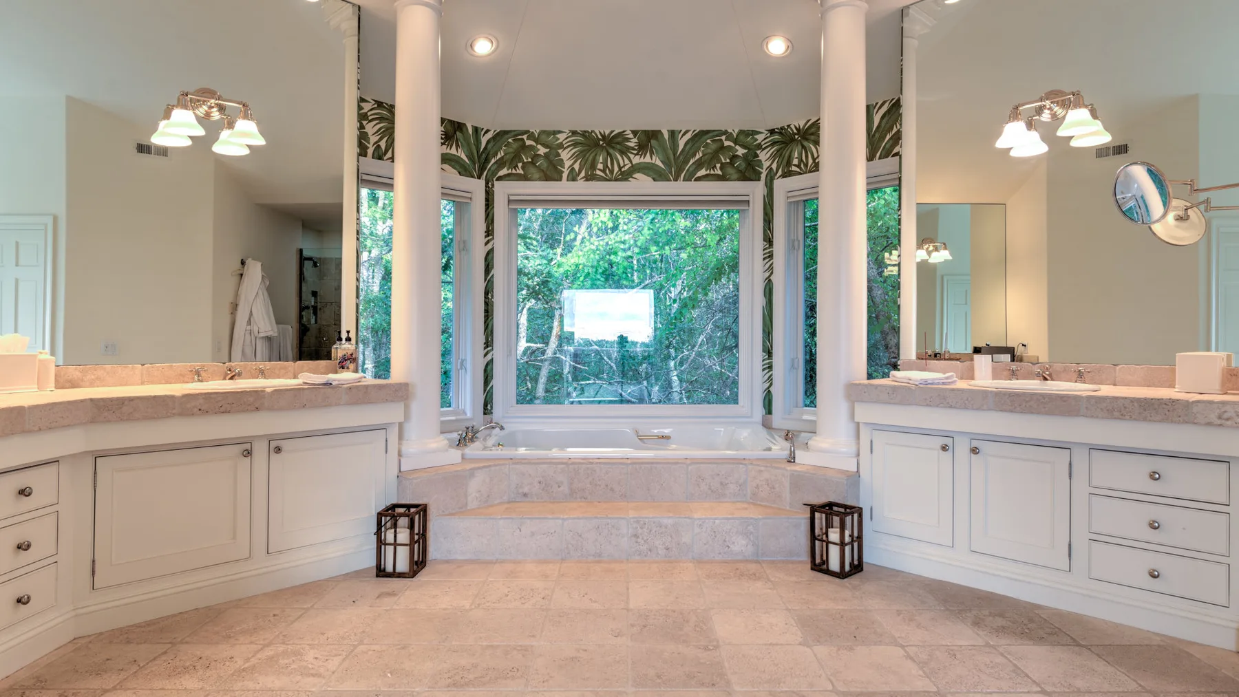 Un baño amplio con dos áreas de tocador y una ventana grande.