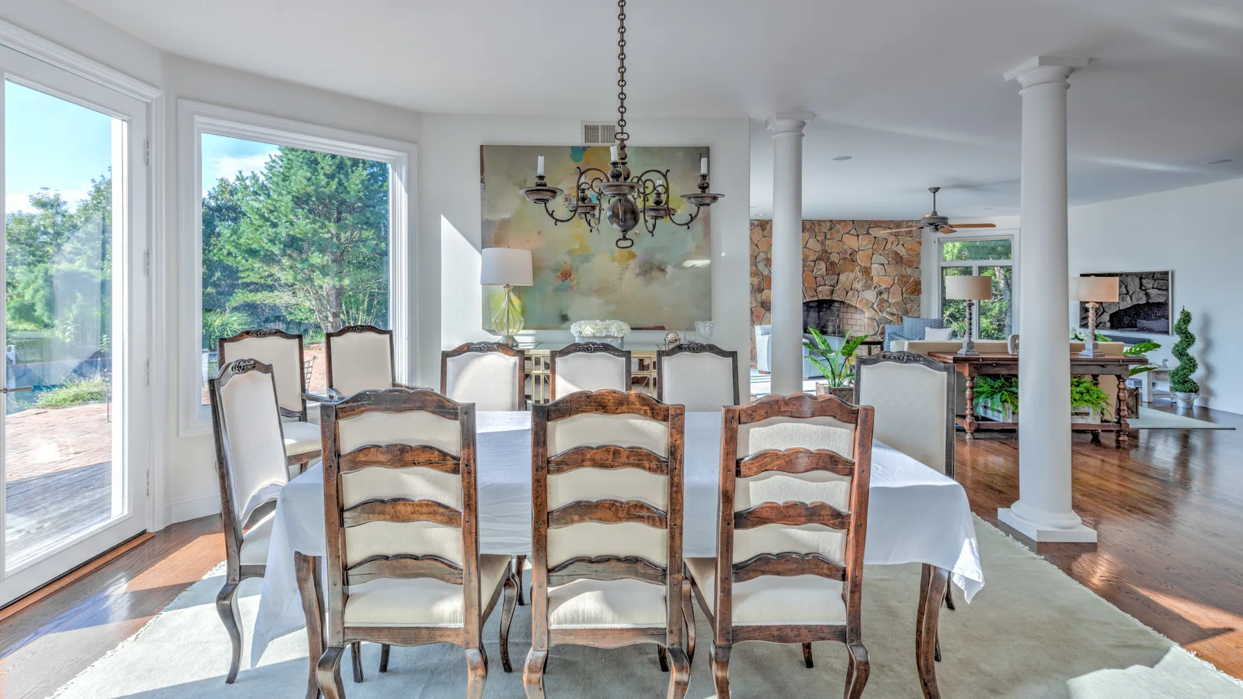 Comedor con una mesa larga, sillas de madera y ventanas amplias.