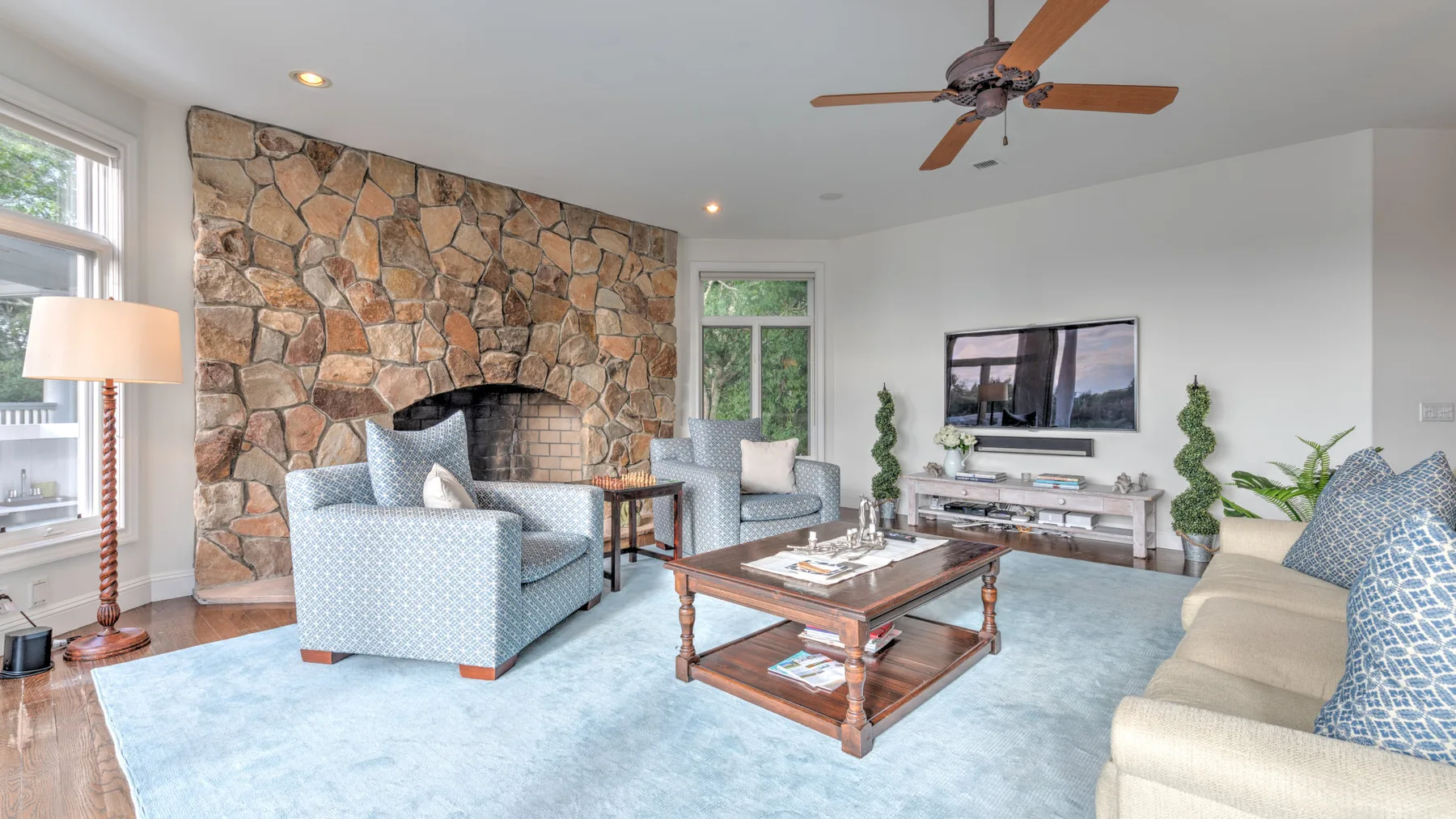Una sala de estar con chimenea de piedra, asientos y una mesa de centro de madera.