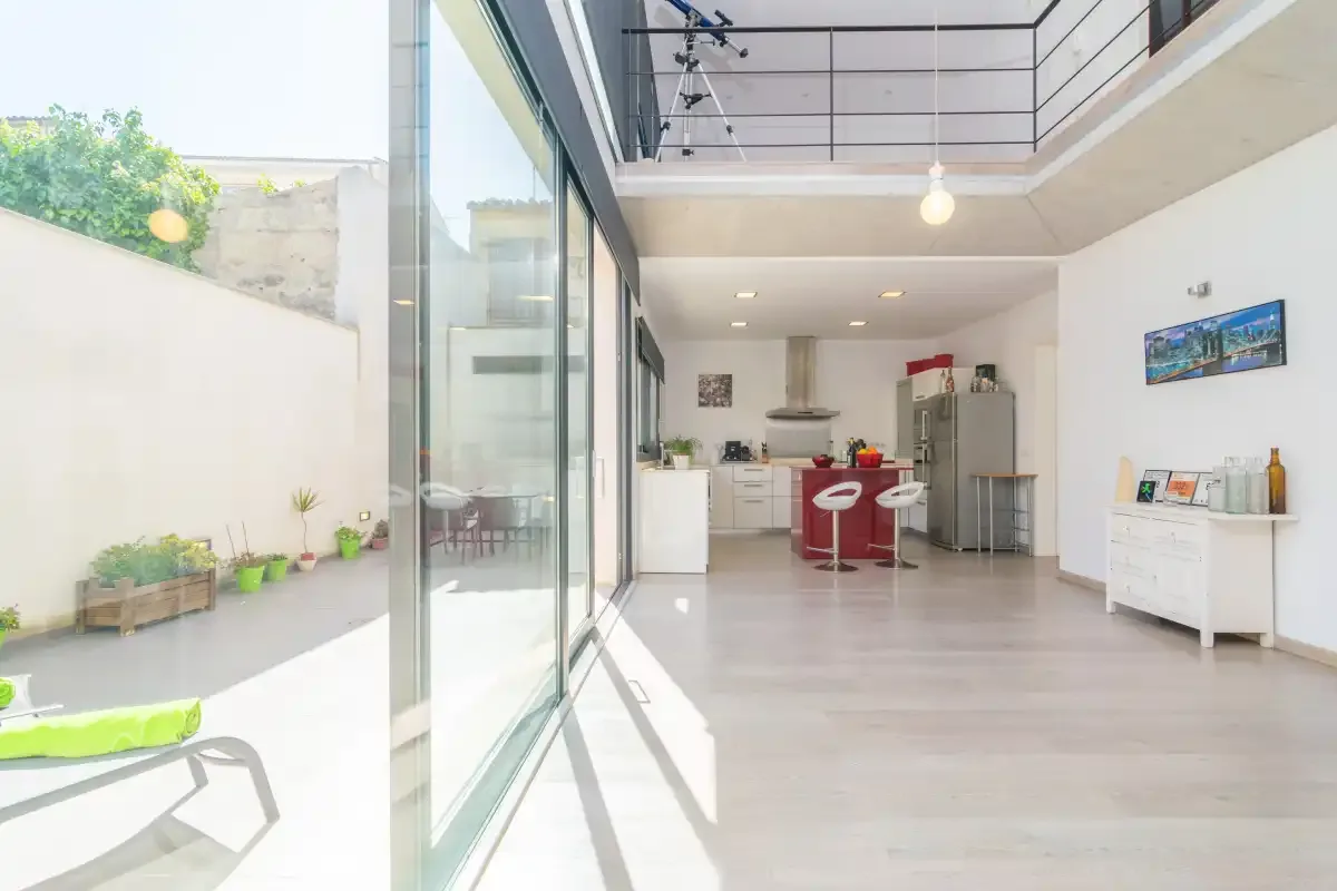 A bright open-plan kitchen and dining area with glass doors opening onto a patio.