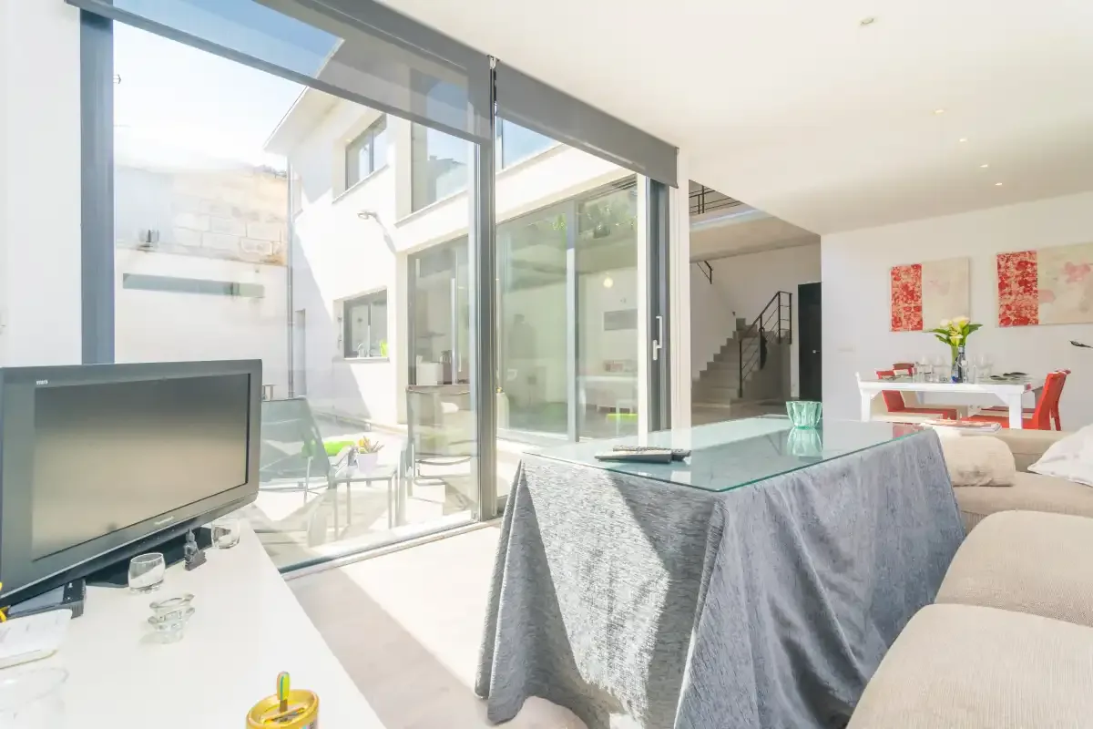 Bright open-plan living and dining area with glass doors opening onto a courtyard.