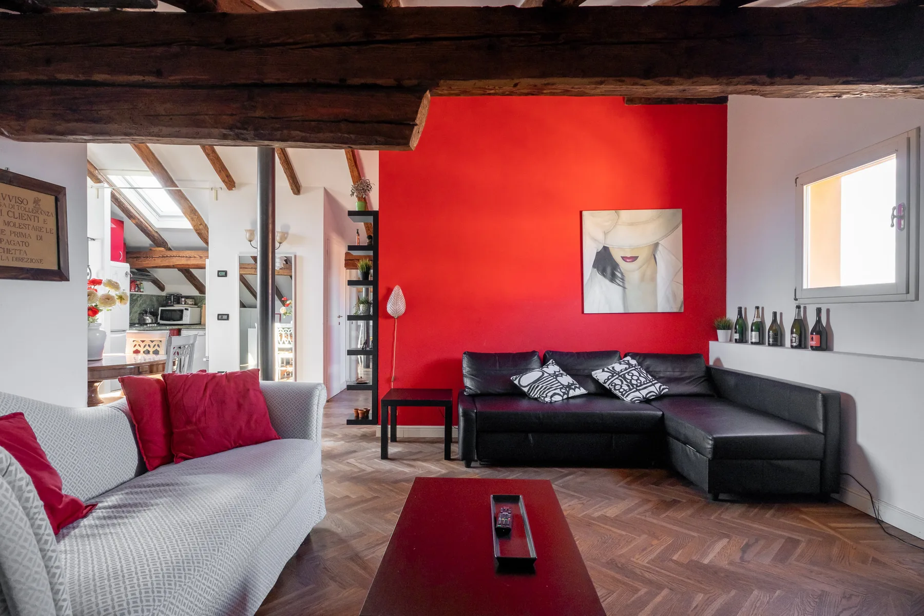Sala de estar con asientos alrededor de una mesa baja y una pared roja.