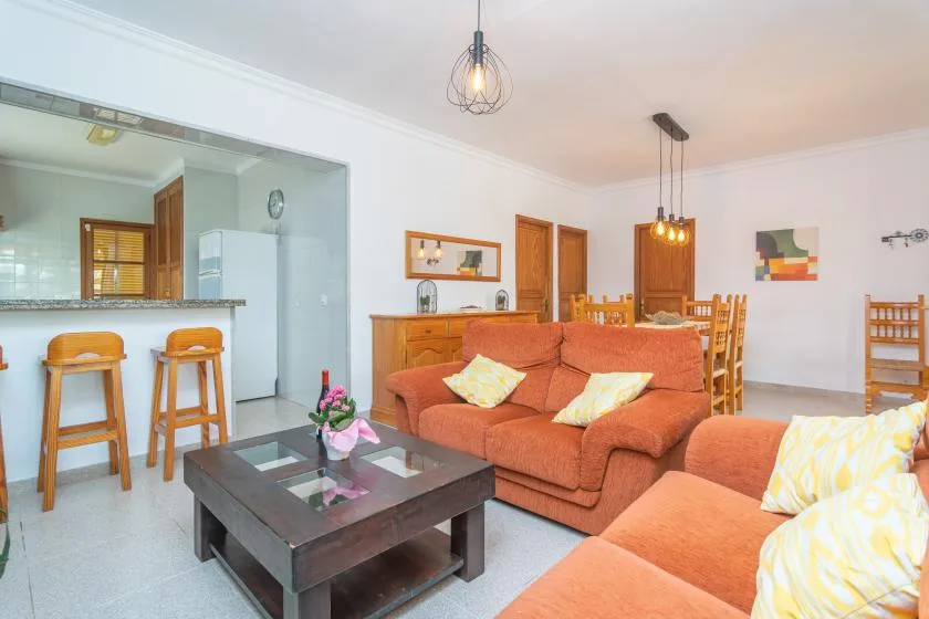 A living and dining area with orange seating and a wooden dining table.