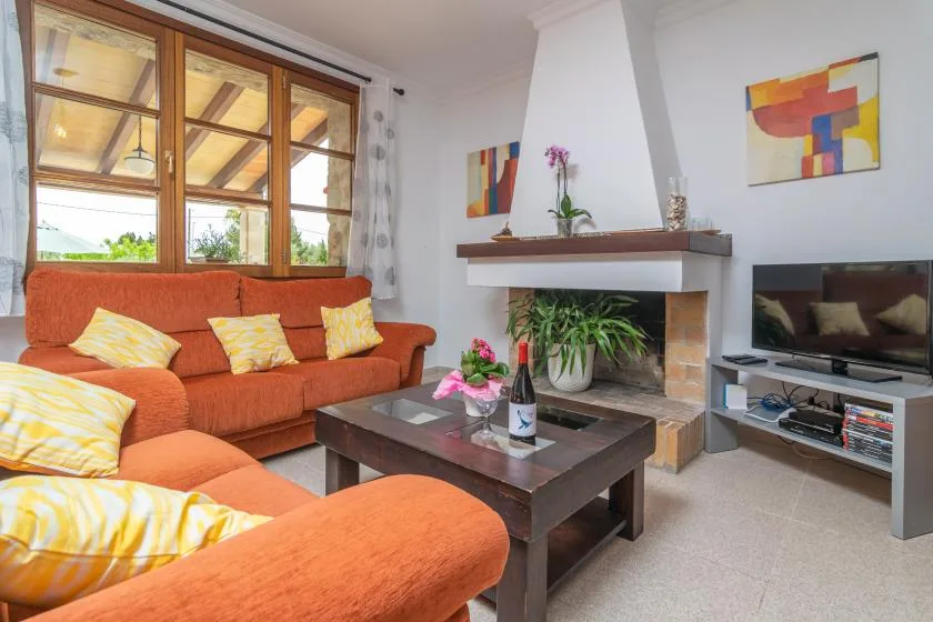 A living room with orange seating, a coffee table, and a fireplace.