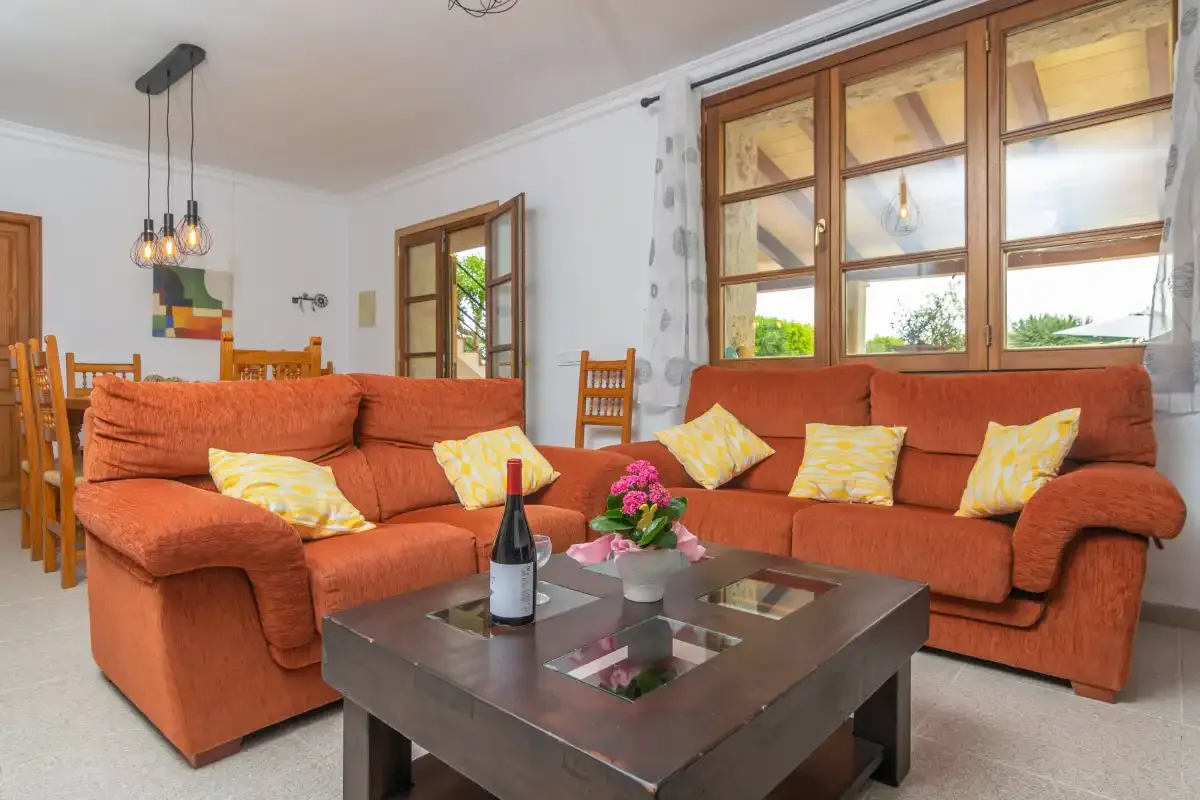 A living room with orange seating arranged around a coffee table.