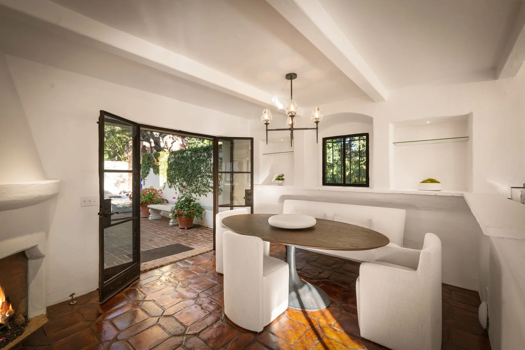 Un comedor luminoso con una mesa redonda y amplias puertas de vidrio hacia un patio.