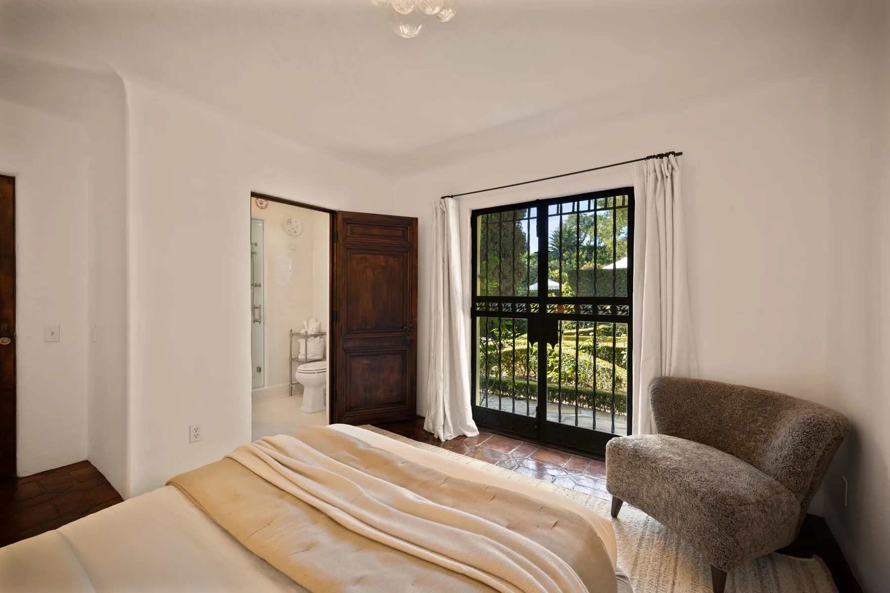 Un dormitorio con una cama y una puerta de vidrio que da a un balcón.