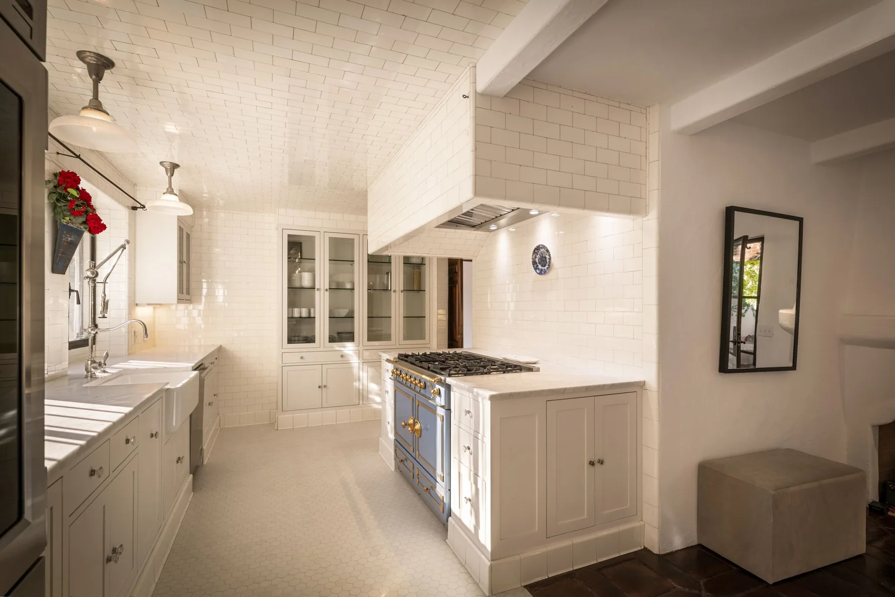Una cocina luminosa con gabinetes blancos, una isla central y una estufa.