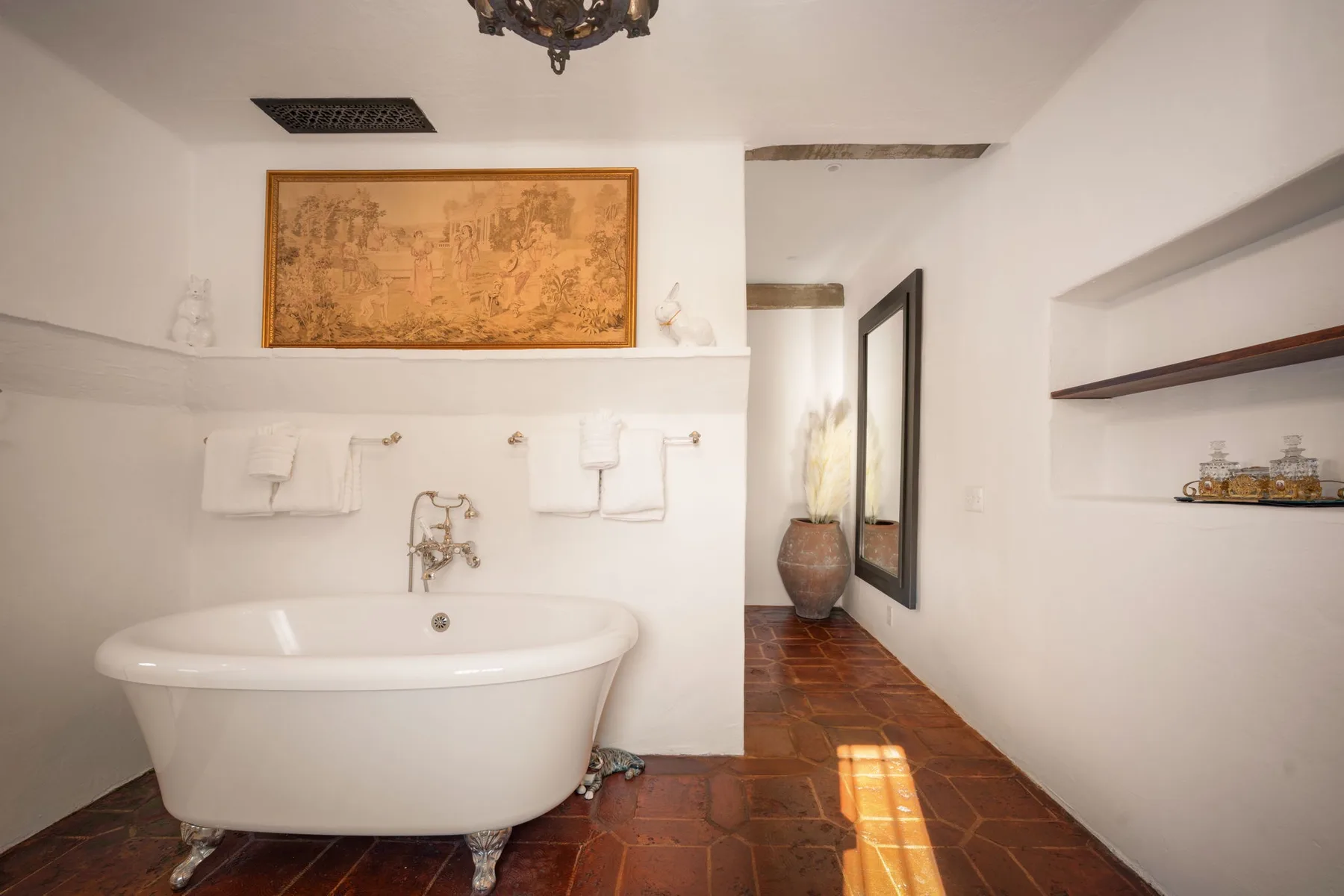 Un baño con una bañera exenta y un suelo de baldosas.