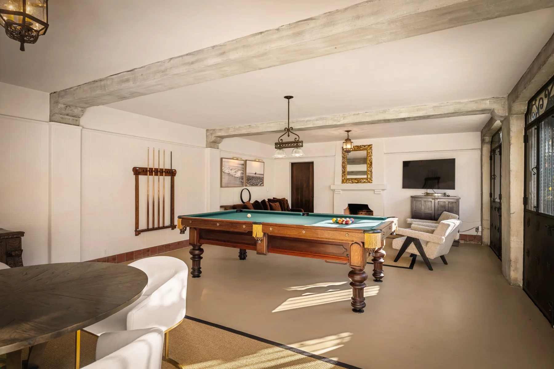 Una sala de billar con una mesa de pool y asientos.