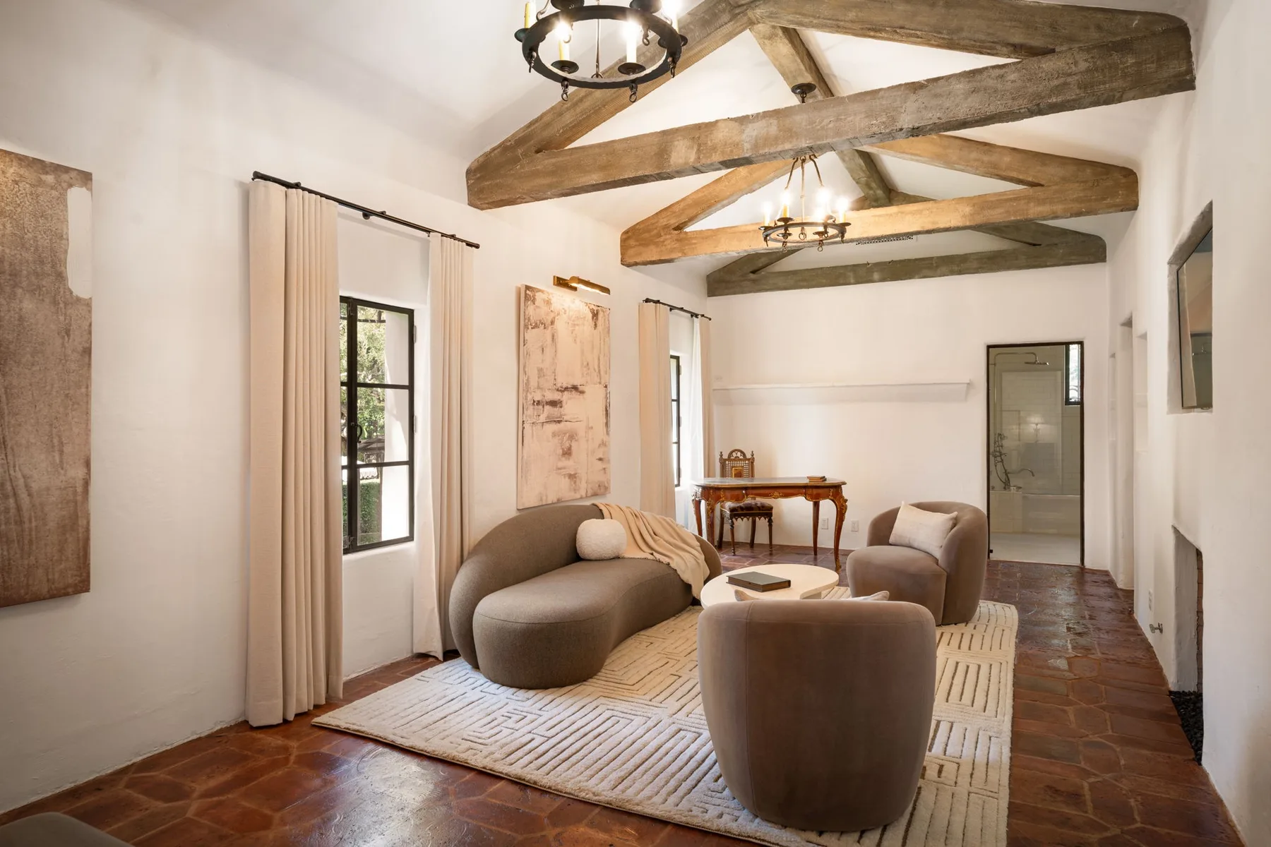 Una luminosa sala de estar con asientos bajo vigas de madera expuestas.