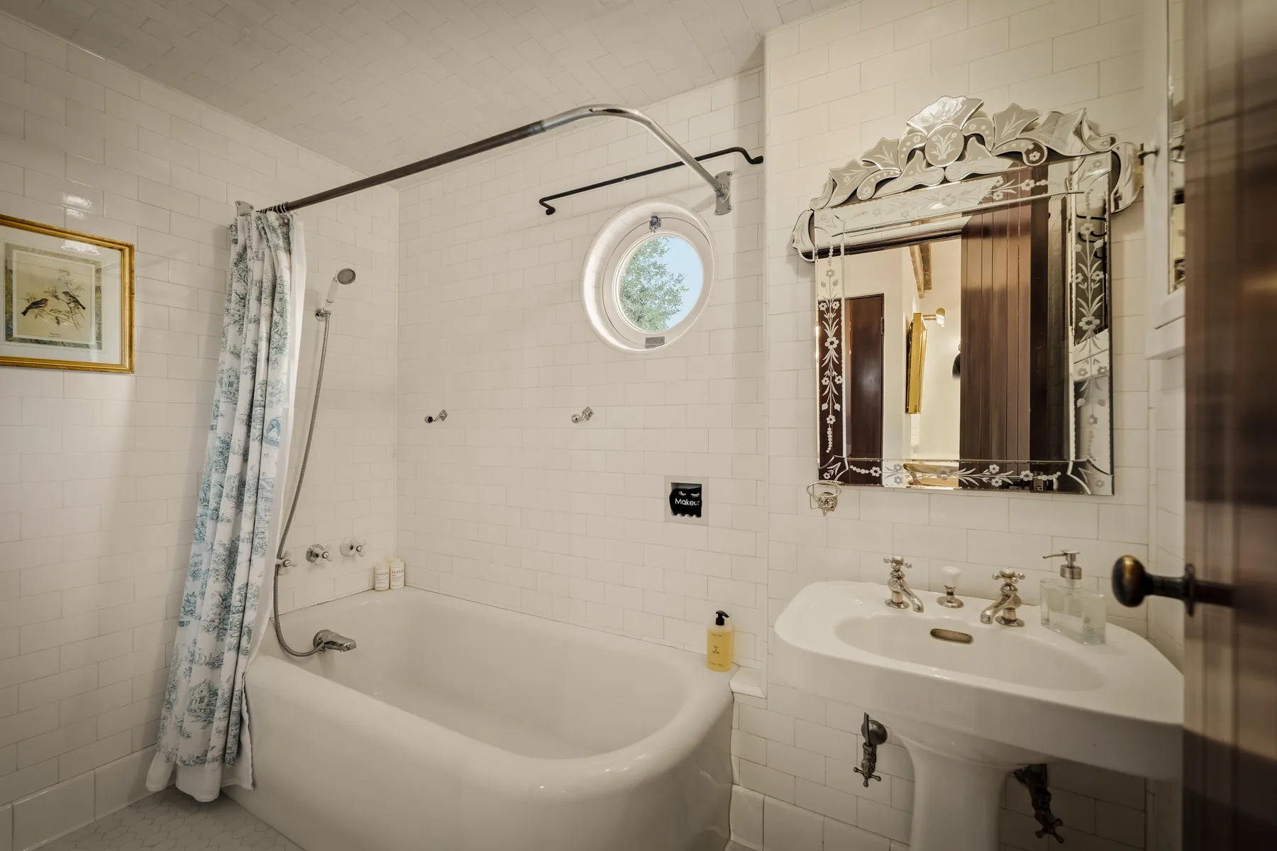 Un baño alicatado con bañera, ducha y lavabo.
