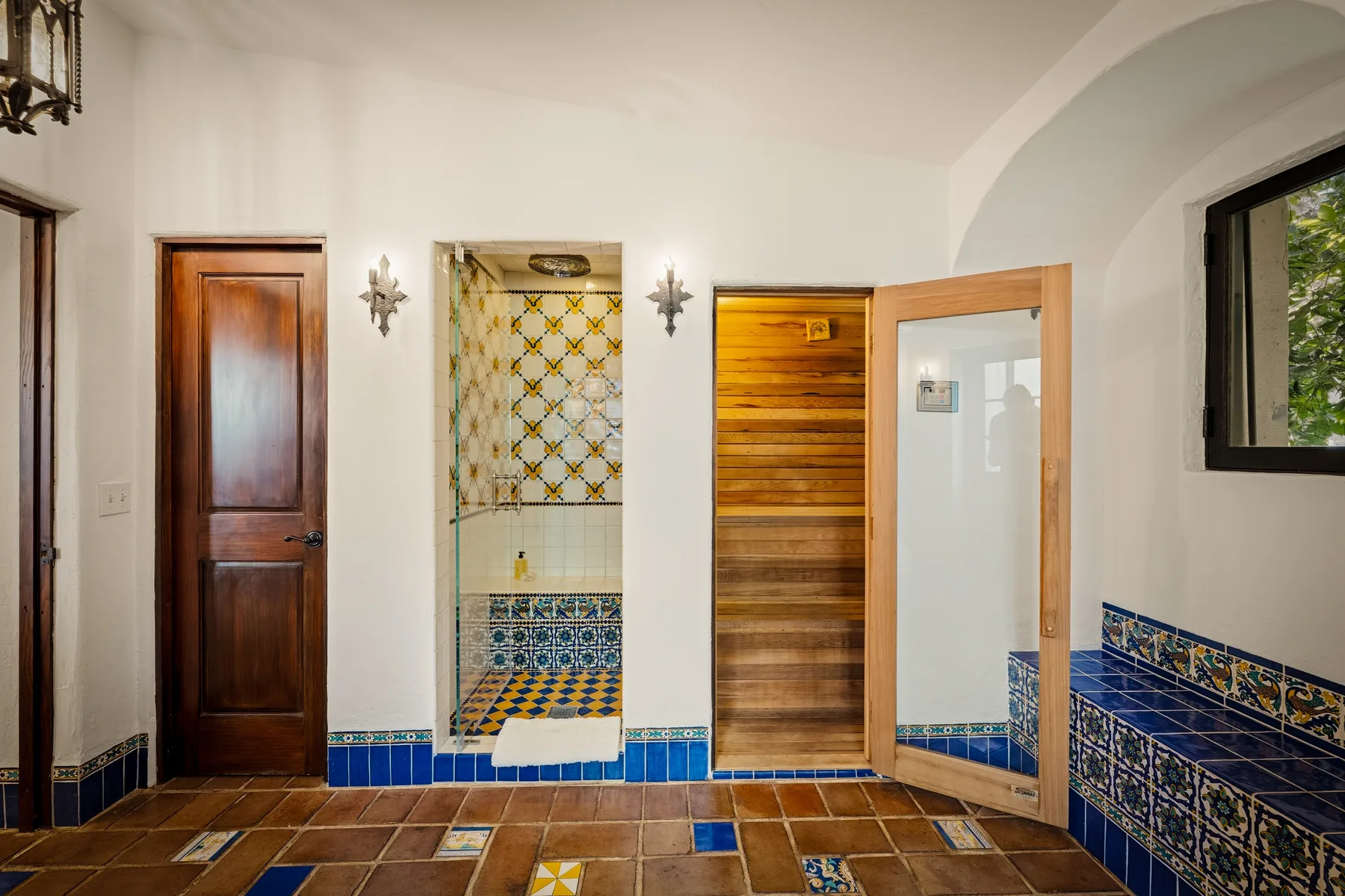 Un baño con azulejos, ducha a ras de suelo y una puerta de madera.