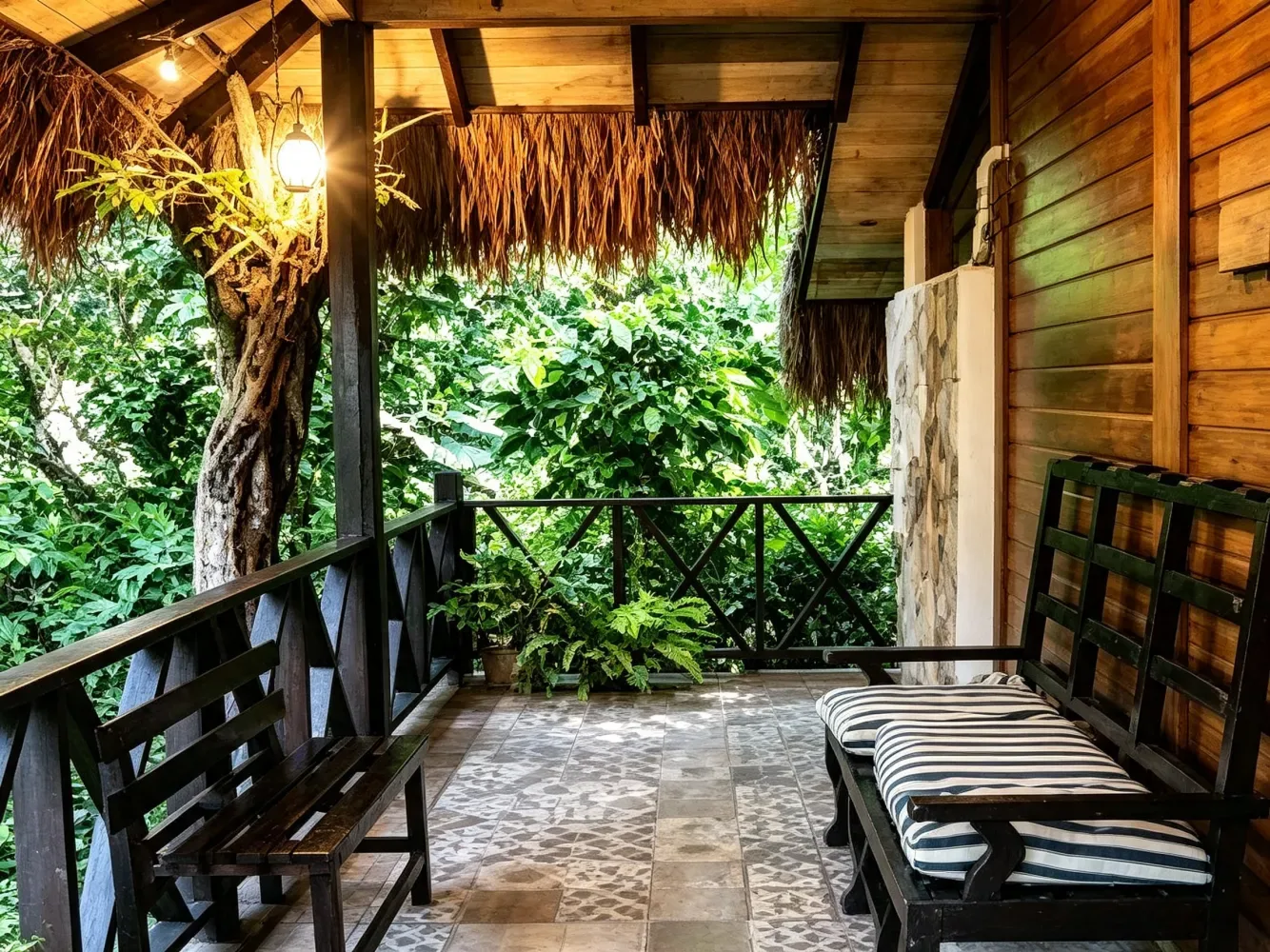 Porche rústico de madera con bancos y follaje tropical.
