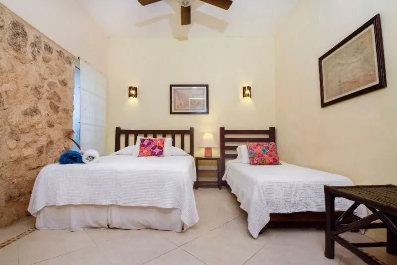 Dormitorio con dos camas individuales y ventilador de techo.