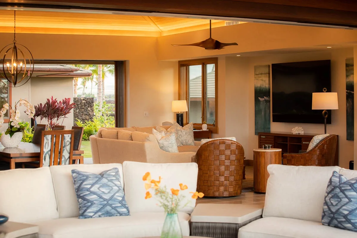 A warm living room with seating, a dining area, and a wall-mounted television.