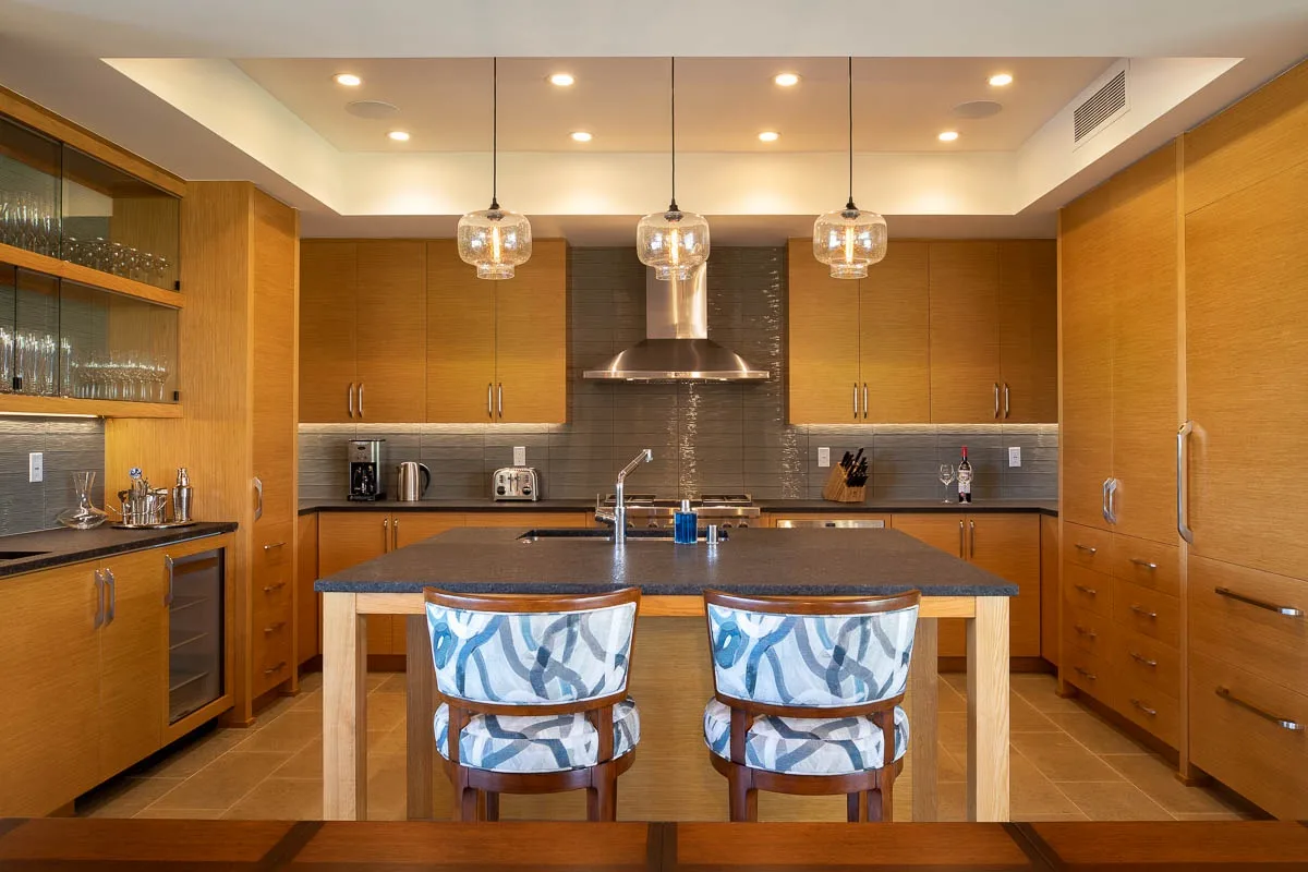 A spacious kitchen with wood cabinetry, a central island, and pendant lights.