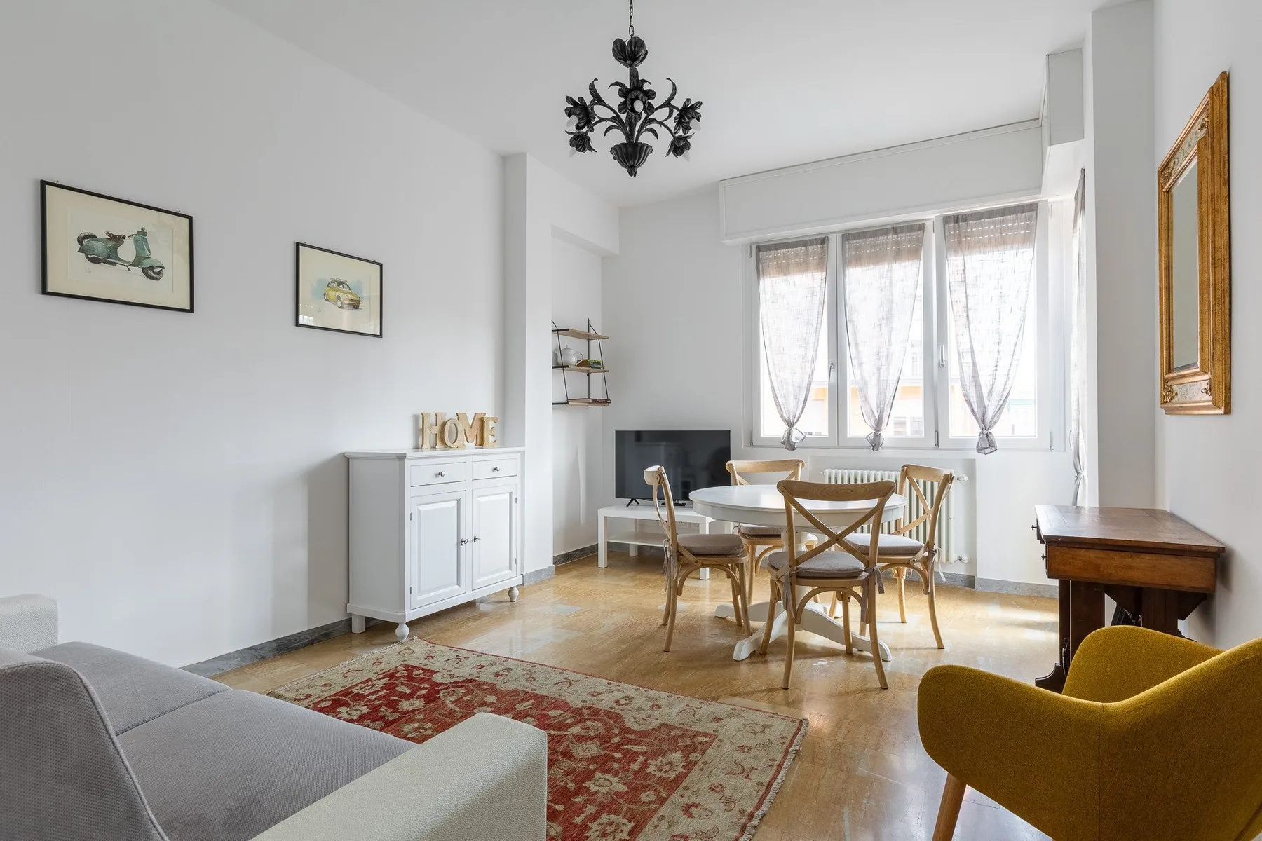 Un salón comedor luminoso con una mesa de madera junto a grandes ventanas.