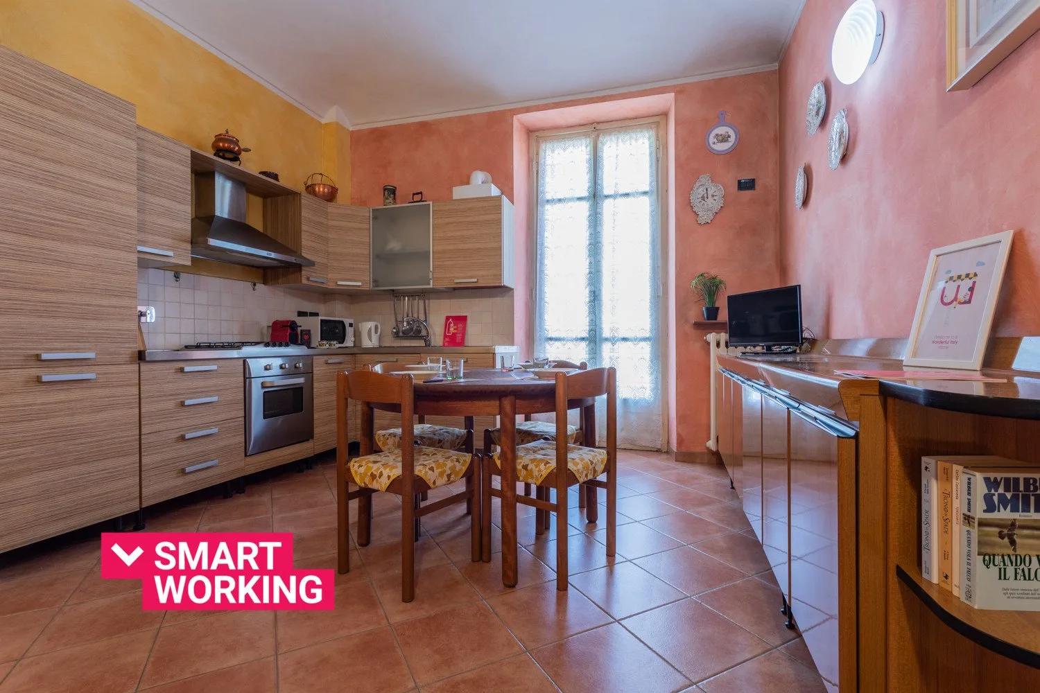 Cocina y comedor con armarios de madera, una mesa y sillas.
