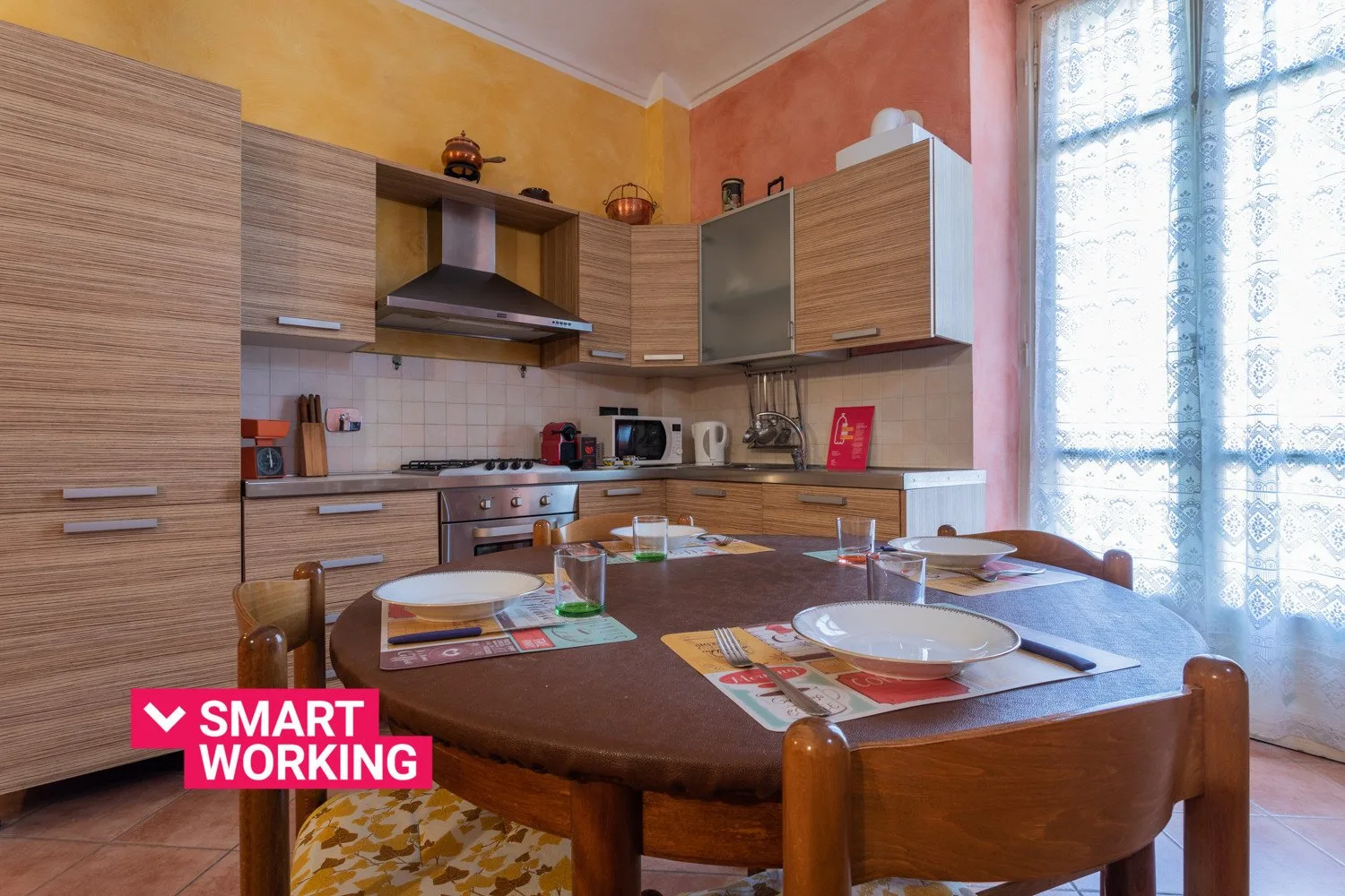 A kitchen dining area with a table set with plates and placemats.