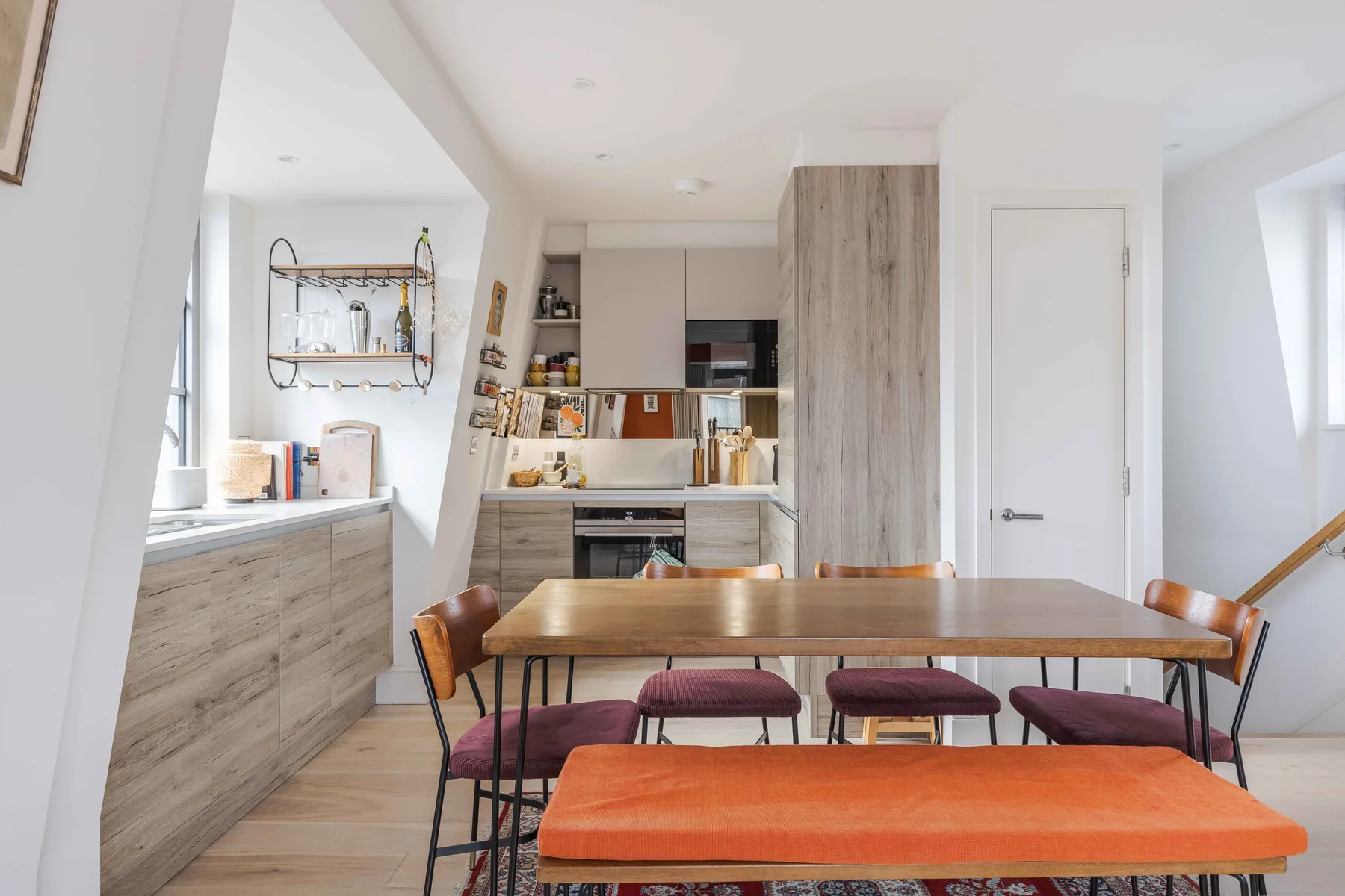 A bright kitchen and dining area with a wooden table and counter seating.