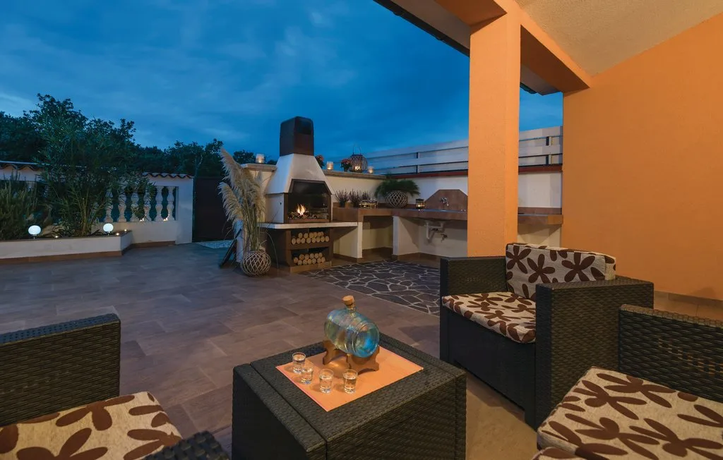 An outdoor patio seating area with a table and a built-in barbecue.