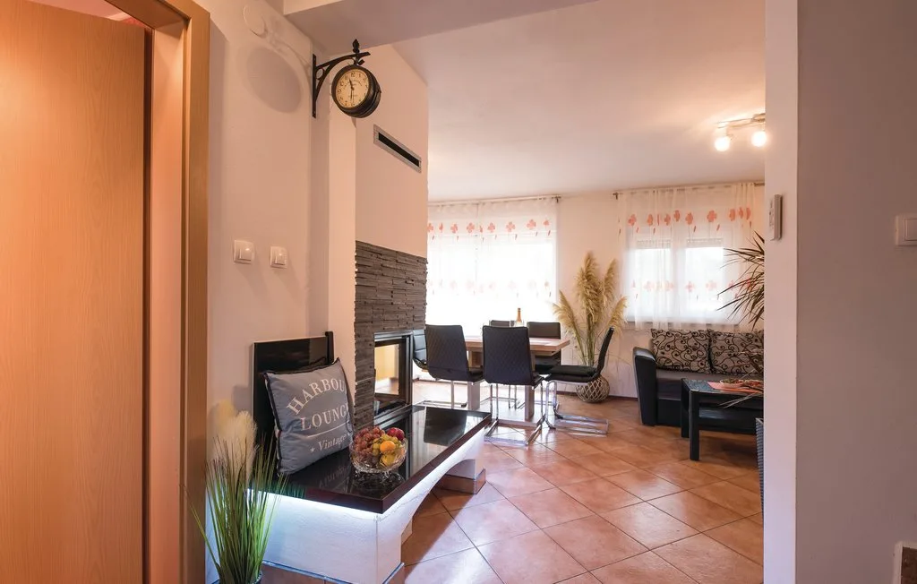 A living room with a dining table and seating beside a tiled floor.