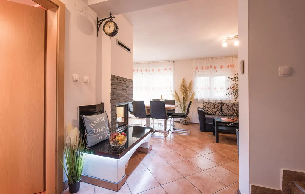 A living and dining area with seating, a dining table, and tiled flooring.