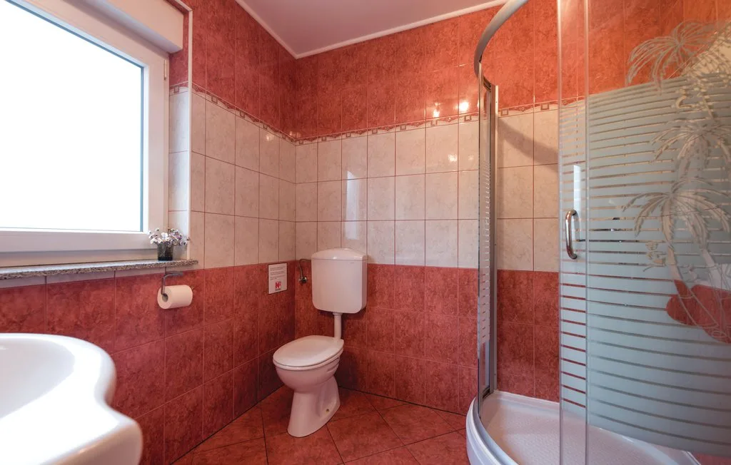 A bathroom with a toilet, sink, and shower.