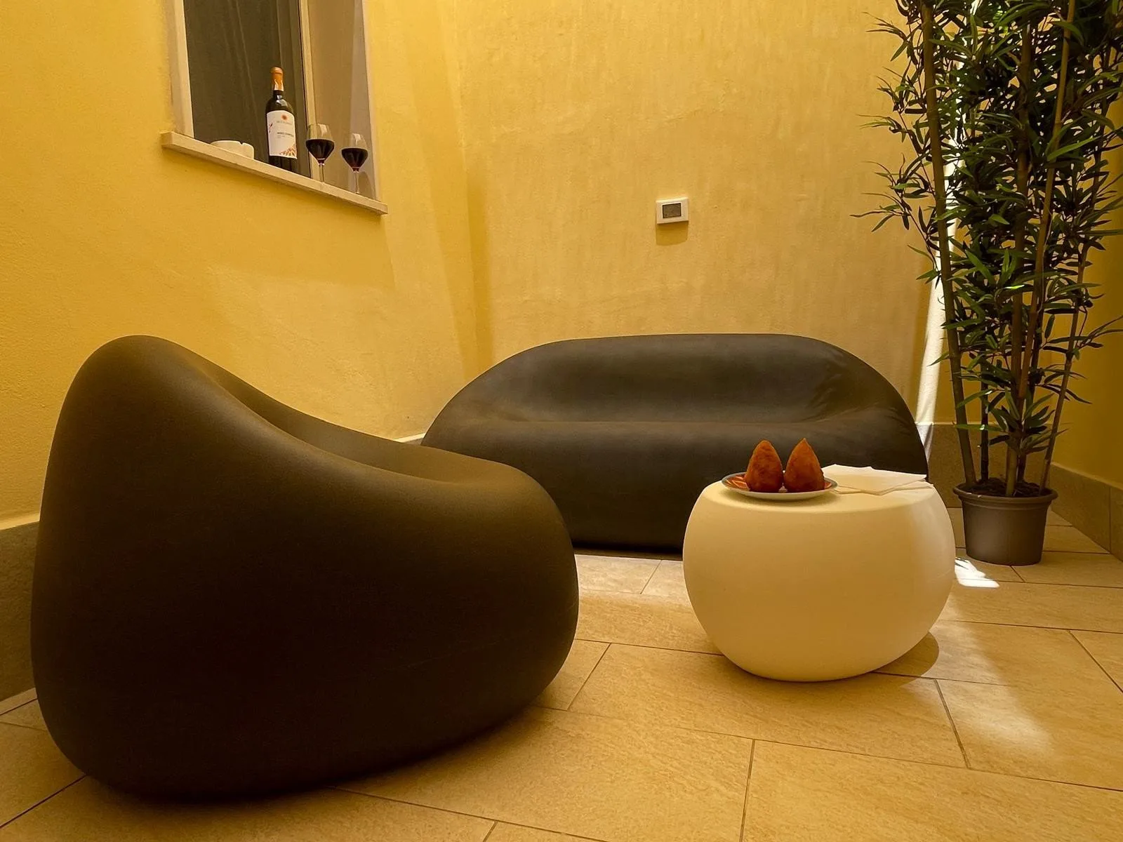 A warm-toned lounge area with curved seating and a small round table.