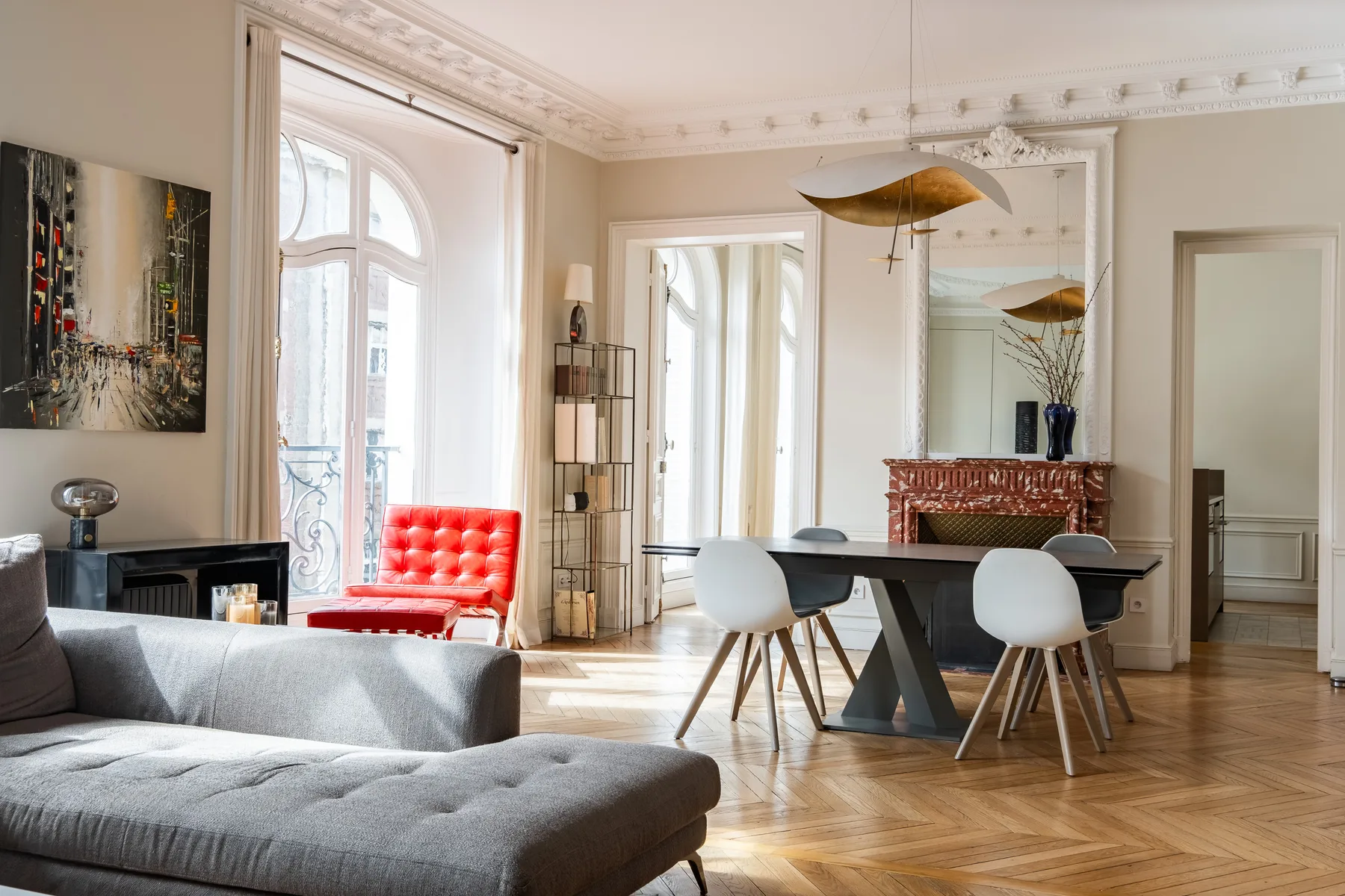 Una luminosa sala de estar y comedor con una zona de asientos gris y una mesa de comedor.