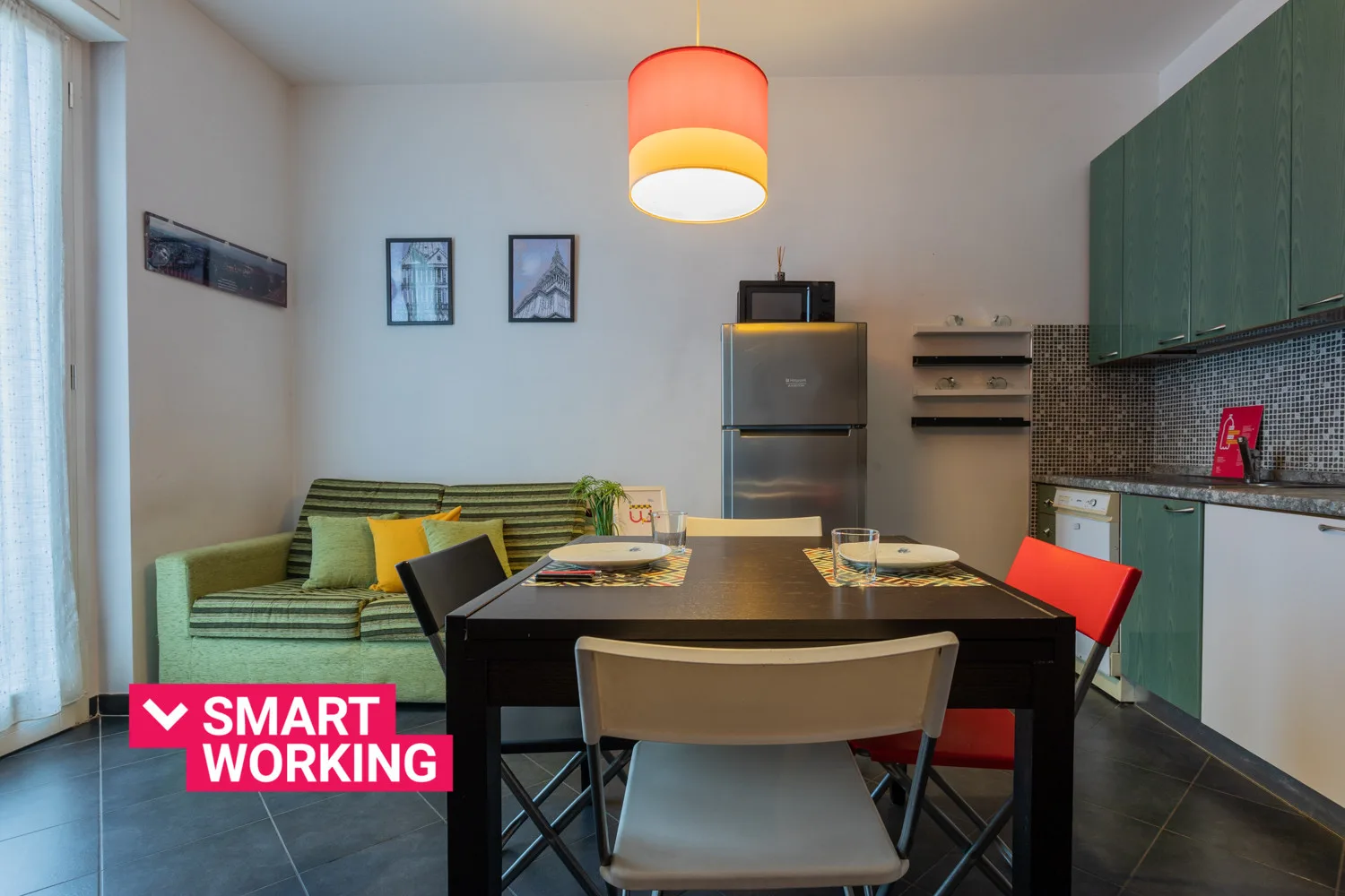 Comedor con una mesa y asientos junto a una cocina compacta.