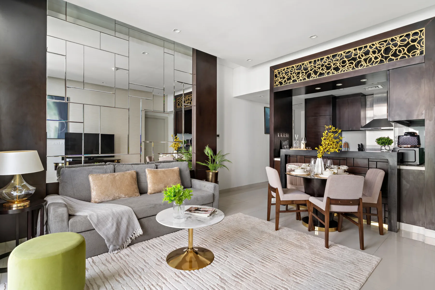Sala de estar y comedor con sofá gris, mesa de comedor y cocina abierta.
