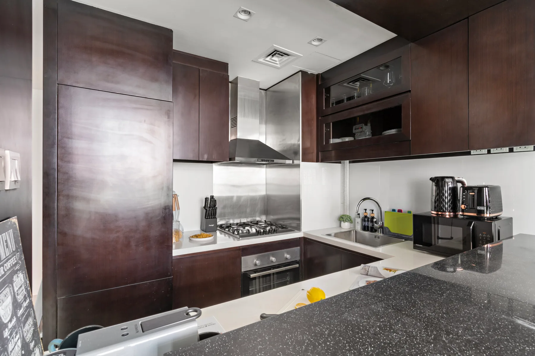 Una cocina moderna con gabinetes oscuros y una estufa.
