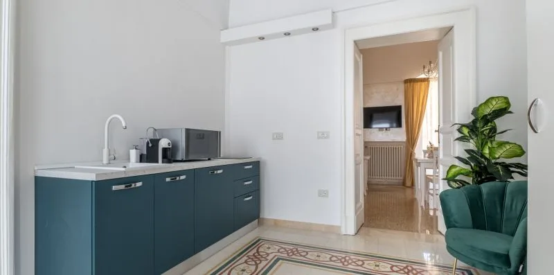 Una cocina luminosa con gabinetes oscuros y una puerta que da a otra habitación.