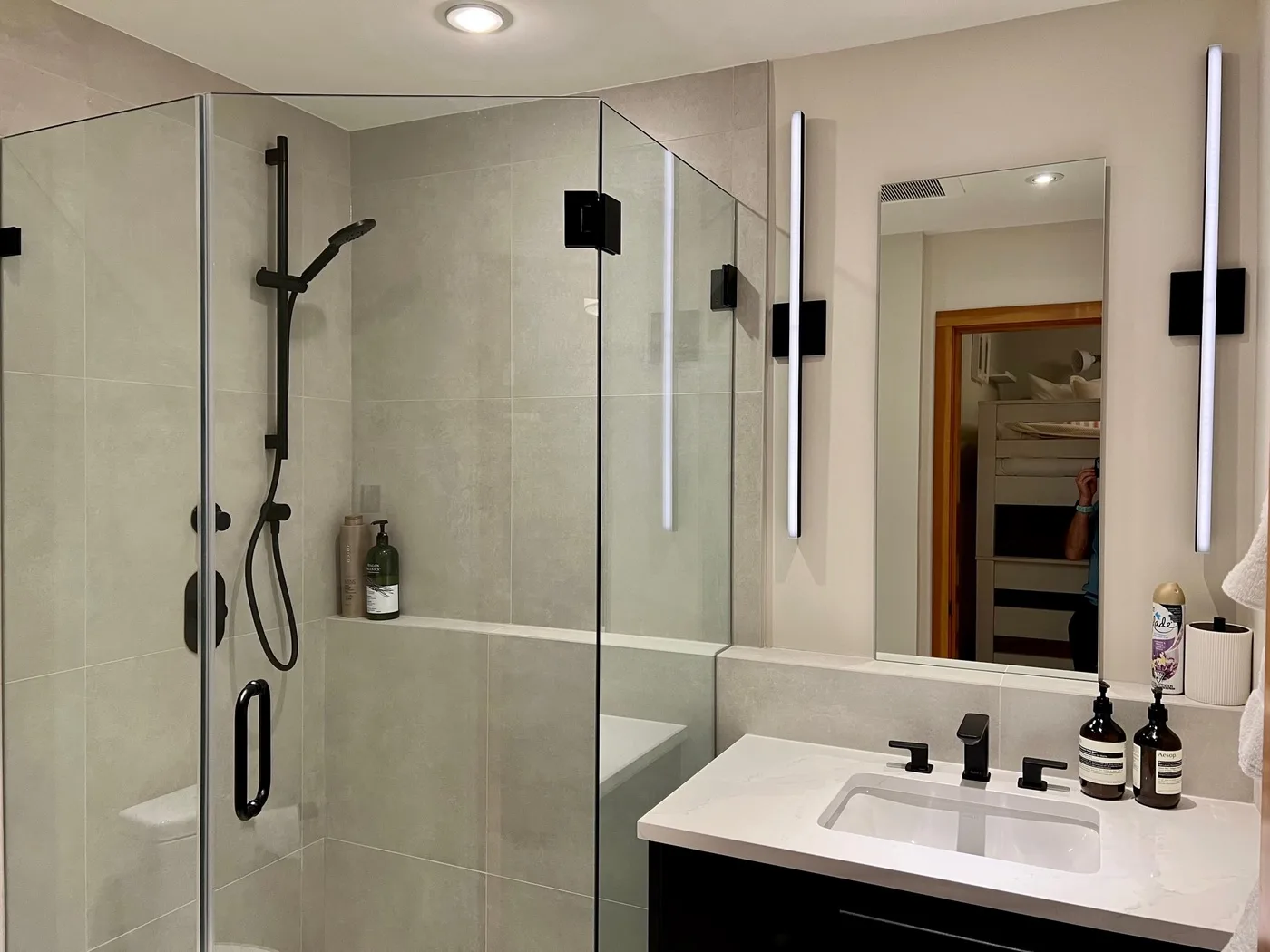 Un baño moderno con una ducha de vidrio y un lavabo con mueble.