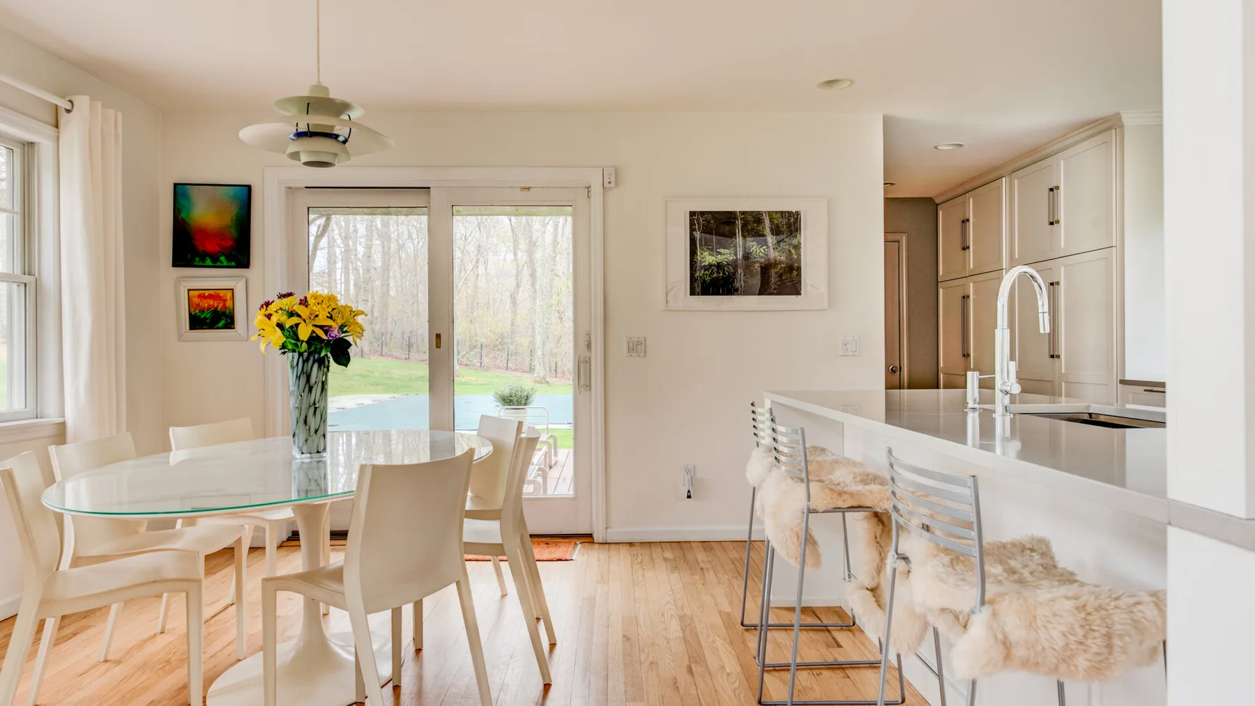 Un comedor luminoso se abre a la cocina, con puertas de vidrio que dan al jardín.