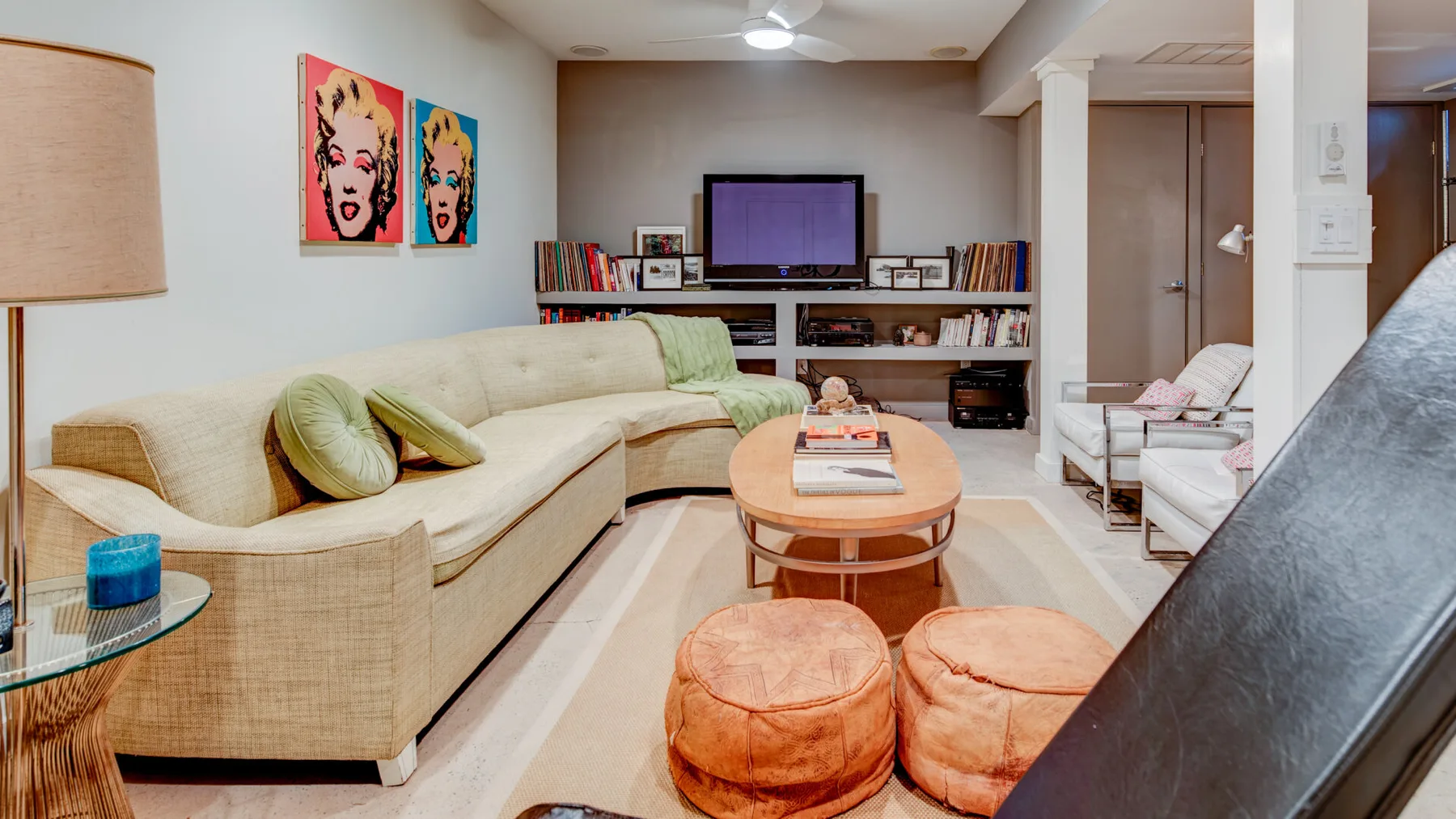 Una sala de estar con un sofá seccional, una mesa de centro y un televisor.